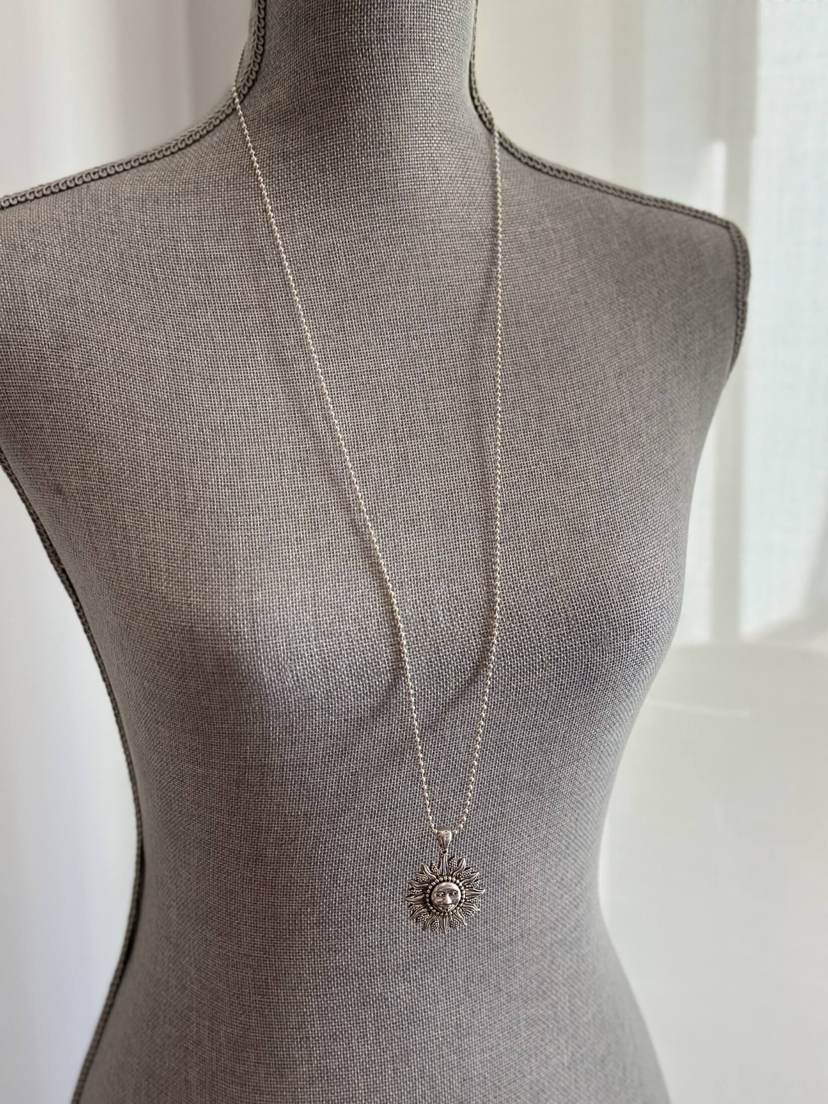 Louise Row featuring silver Lago Sun necklace on grey mannequin