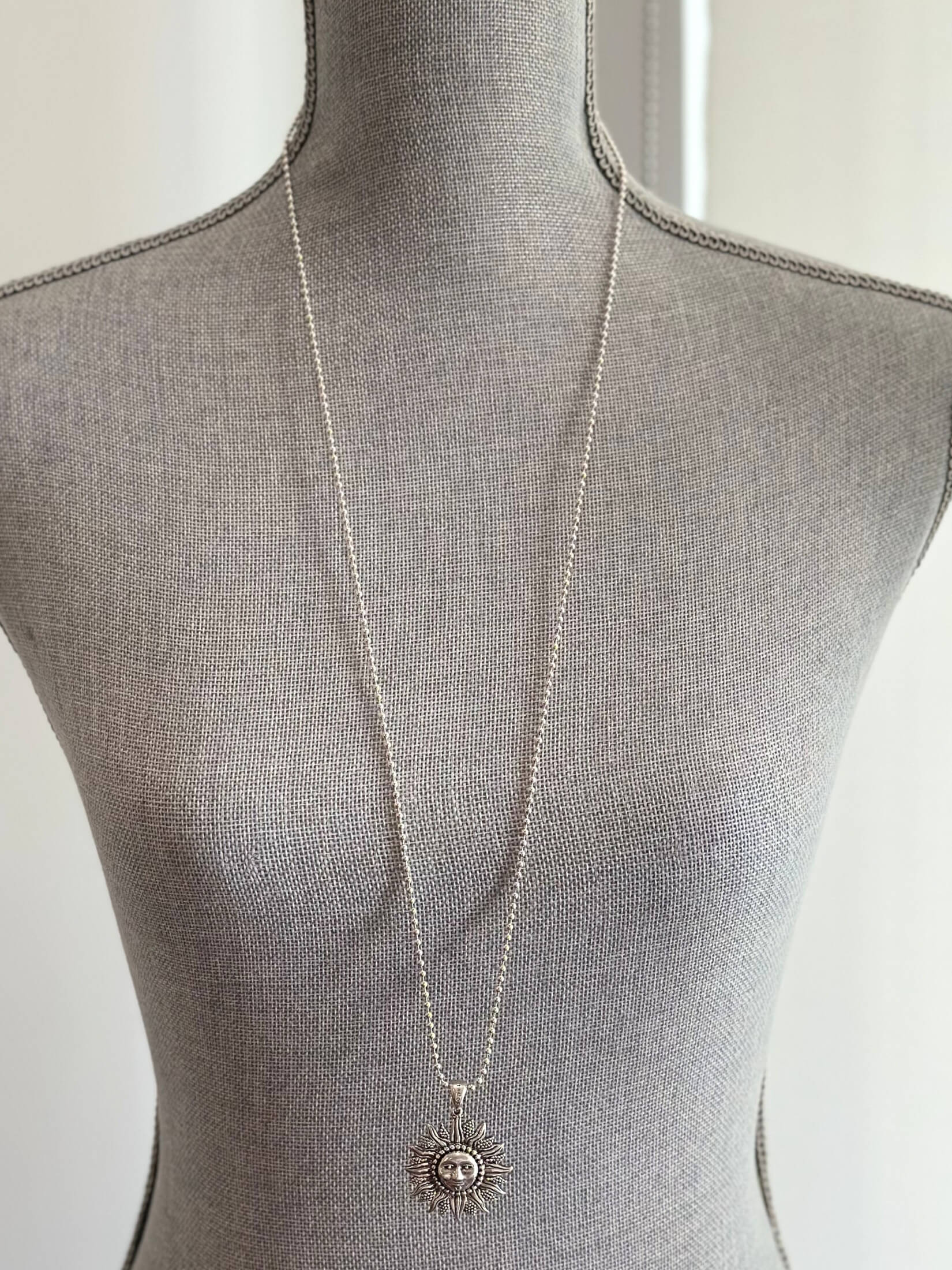 Louise Row featuring silver Lago Sun necklace on grey mannequin
