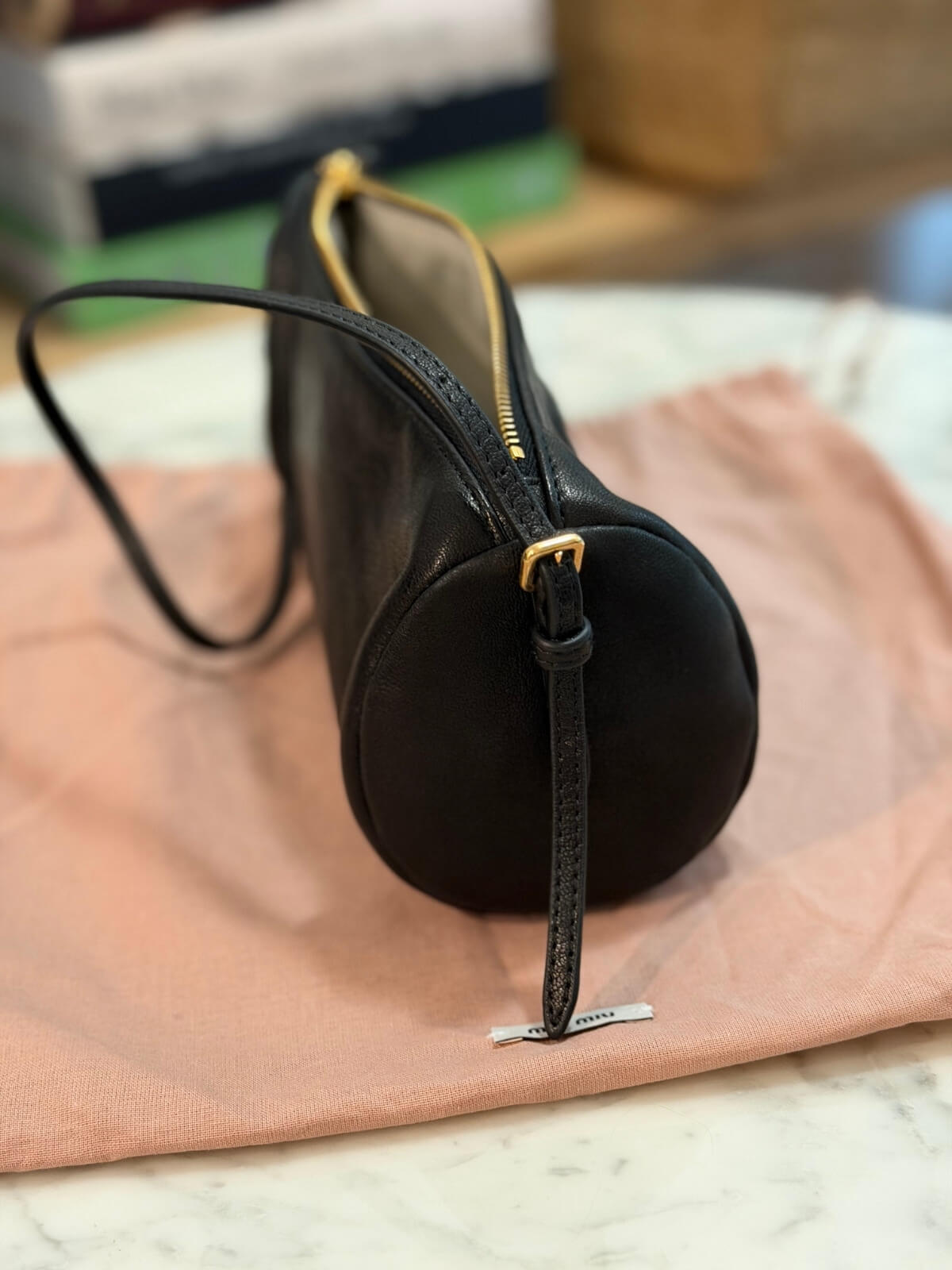 Louise Row featuring Miu Miu Nappa Black shoulder bag on table with books