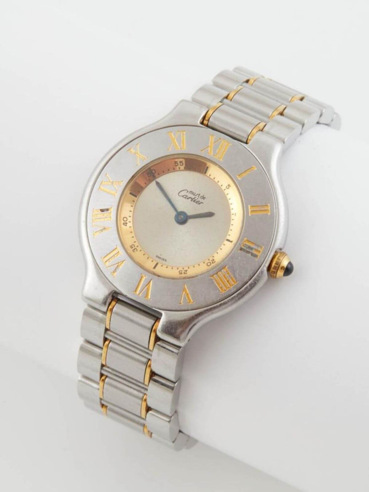 Must De Cartier stainless steel and gold watch on white background. Round face
