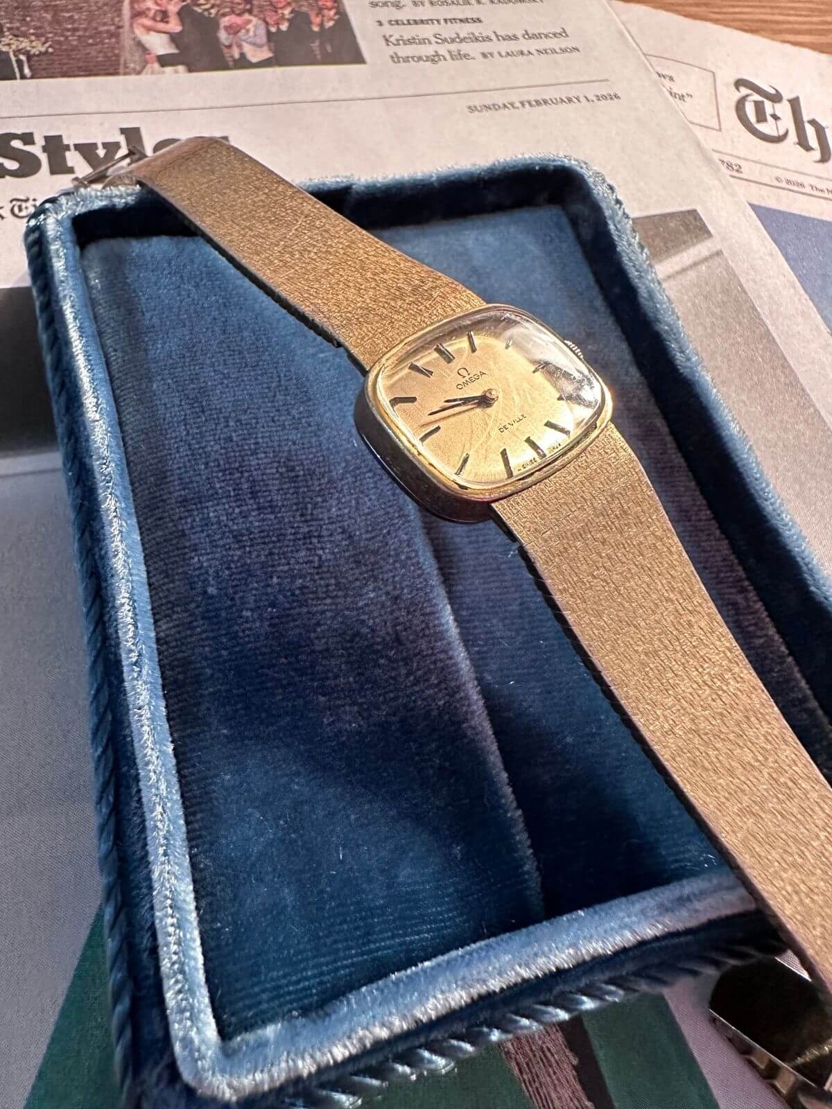 Louise Row Studio featuring Gold Omega De Ville watch with papers in background