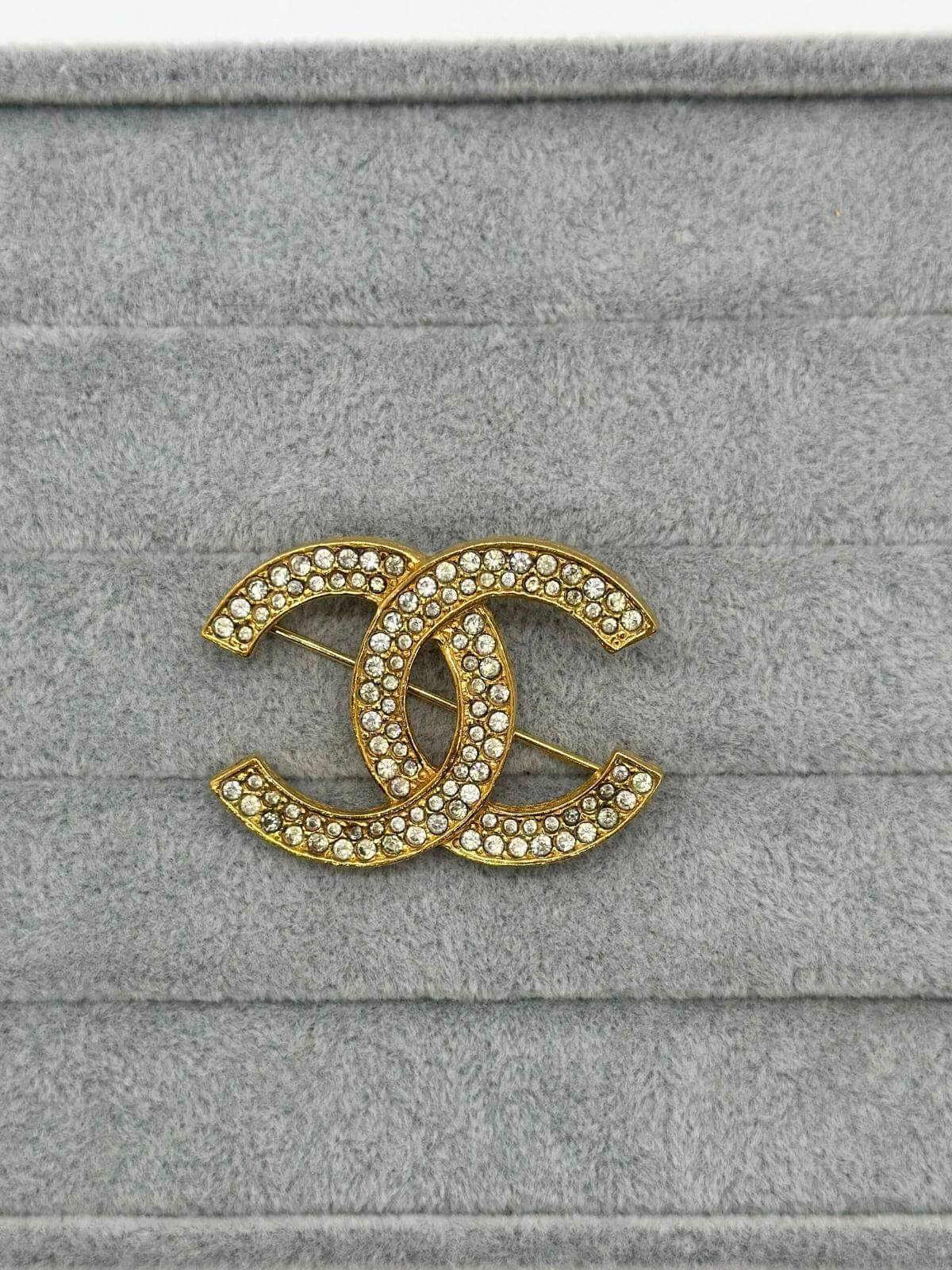 Pre-loved Chanel crystal brooch on grey background