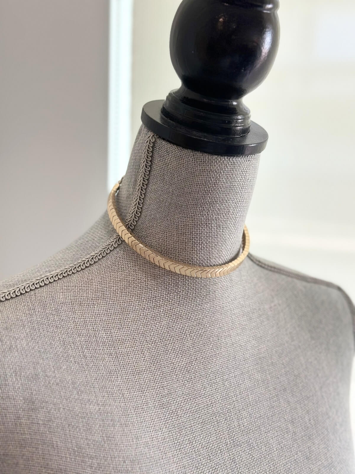 Louise Row featuring Roxanne Assoulin gold choker on grey mannequin