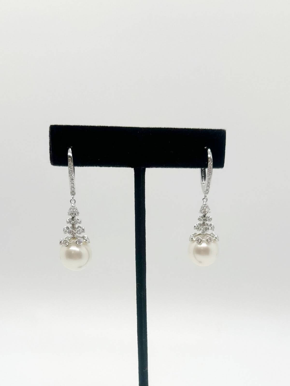 South Sea pearl and diamond drop earring with white background and on black fixture.