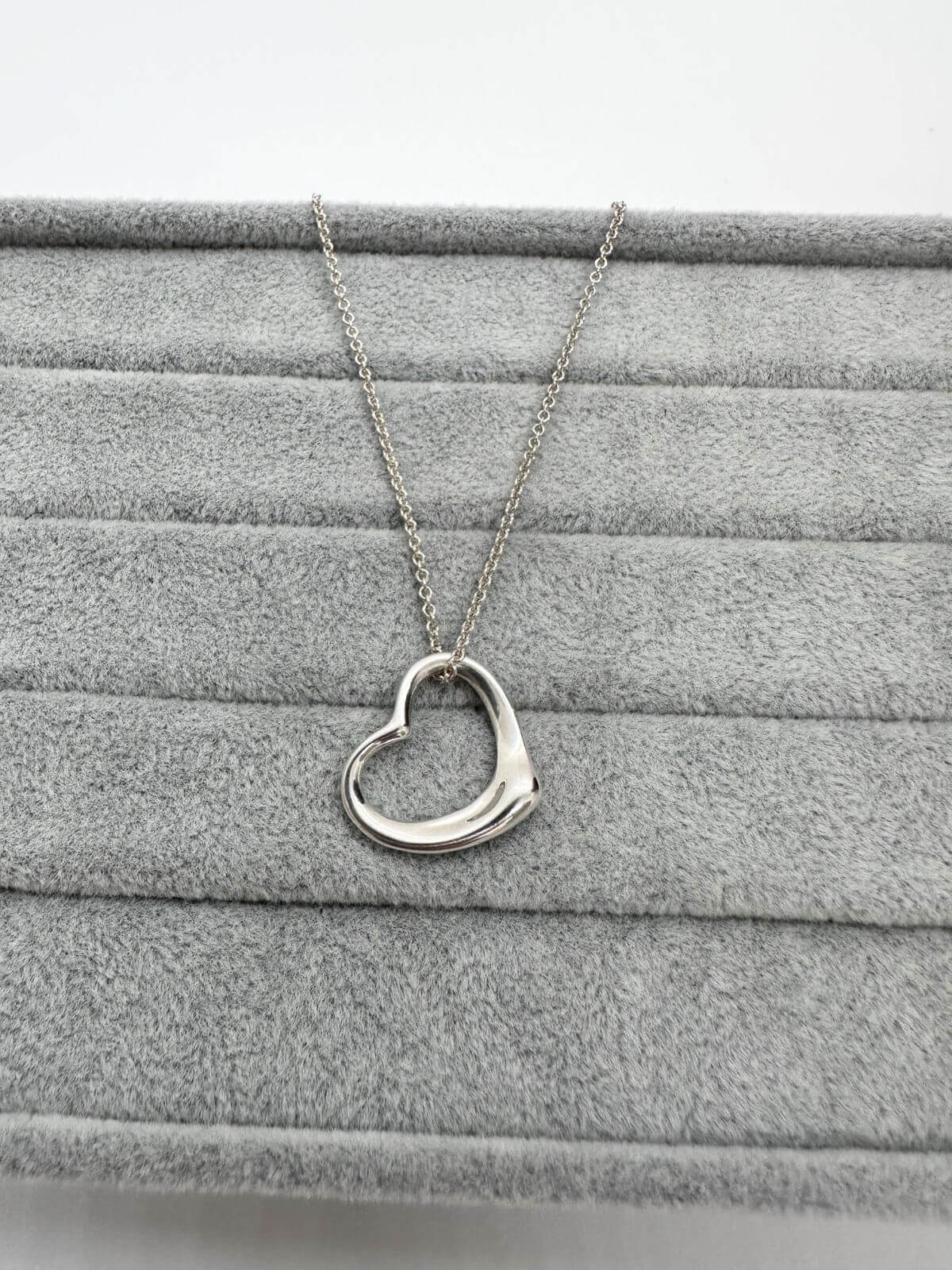 Tiffany open heart necklace on grey background