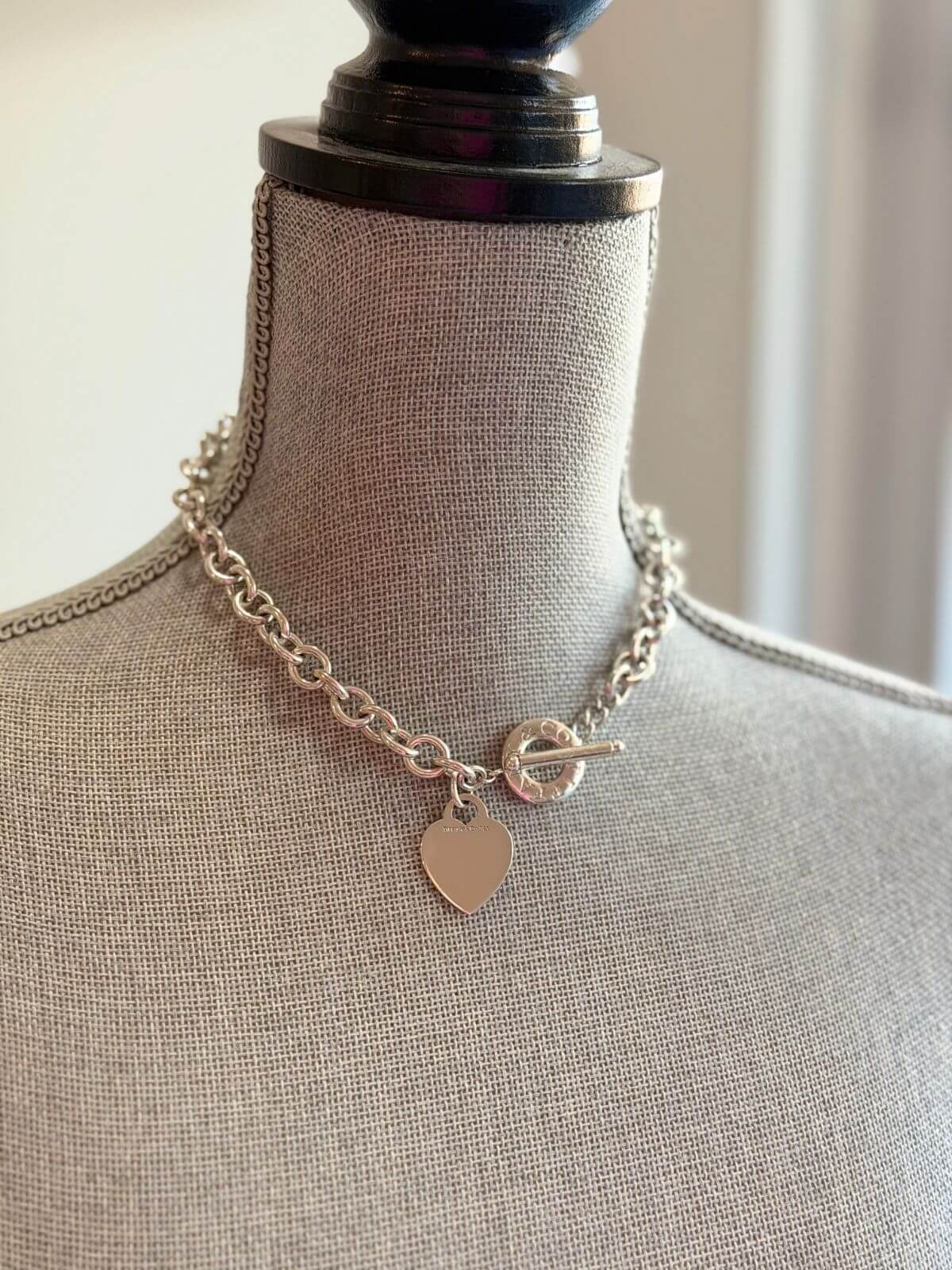 Louise Row featuring Tiffany Return to Me toggle necklace in silver on grey mannequin
