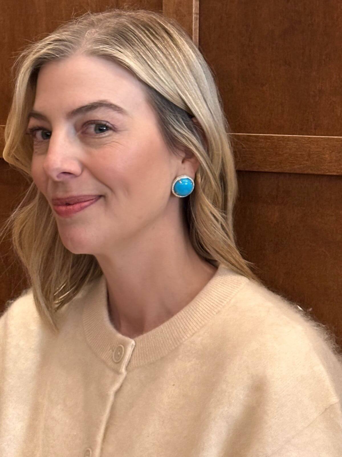 Louise Row Studio featuring Turquoise and Diamond round earrings with diamonds on model in white sweater.