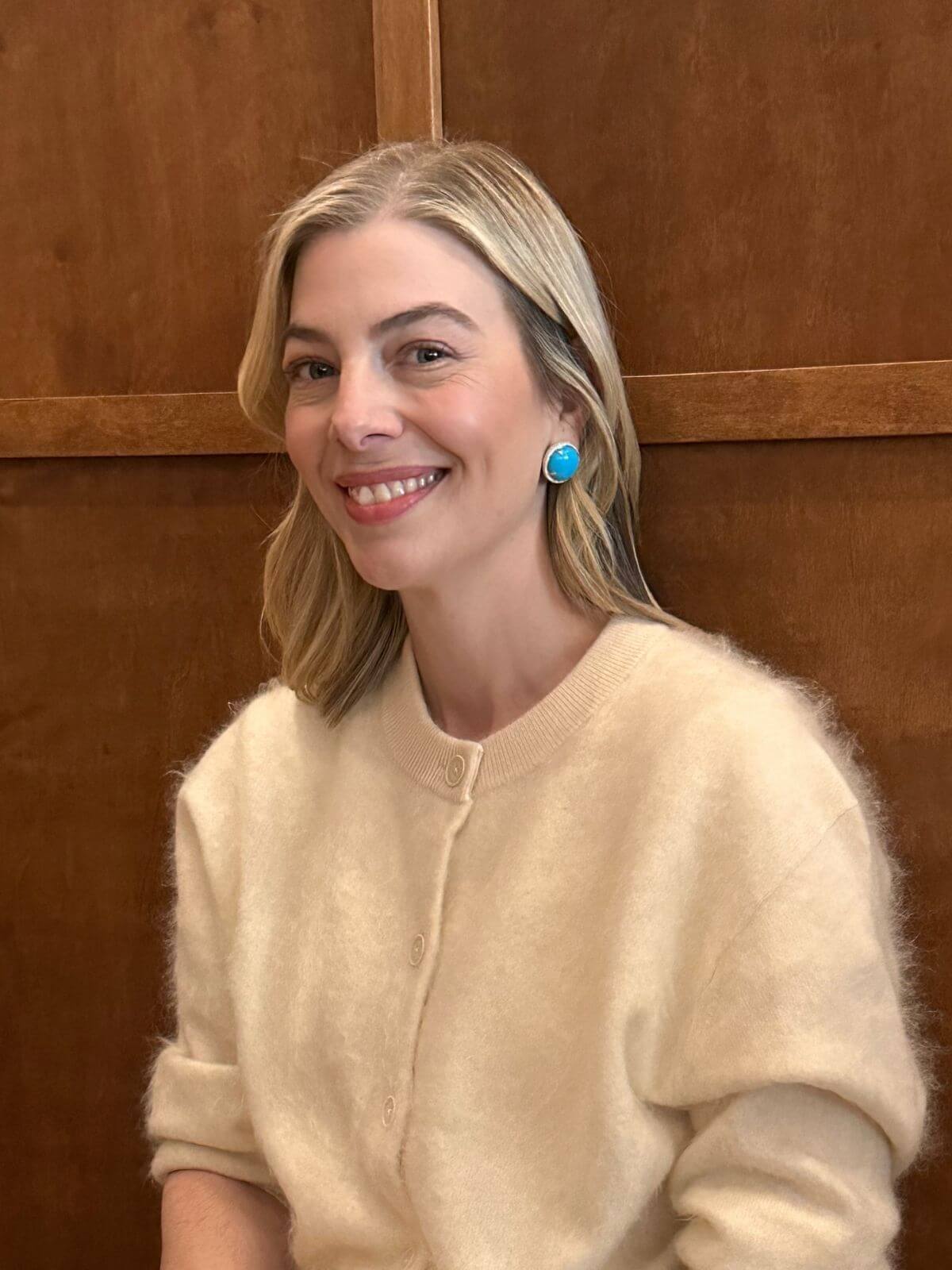Louise Row Studio featuring Turquoise and Diamond round earrings with diamonds on model with white sweater.