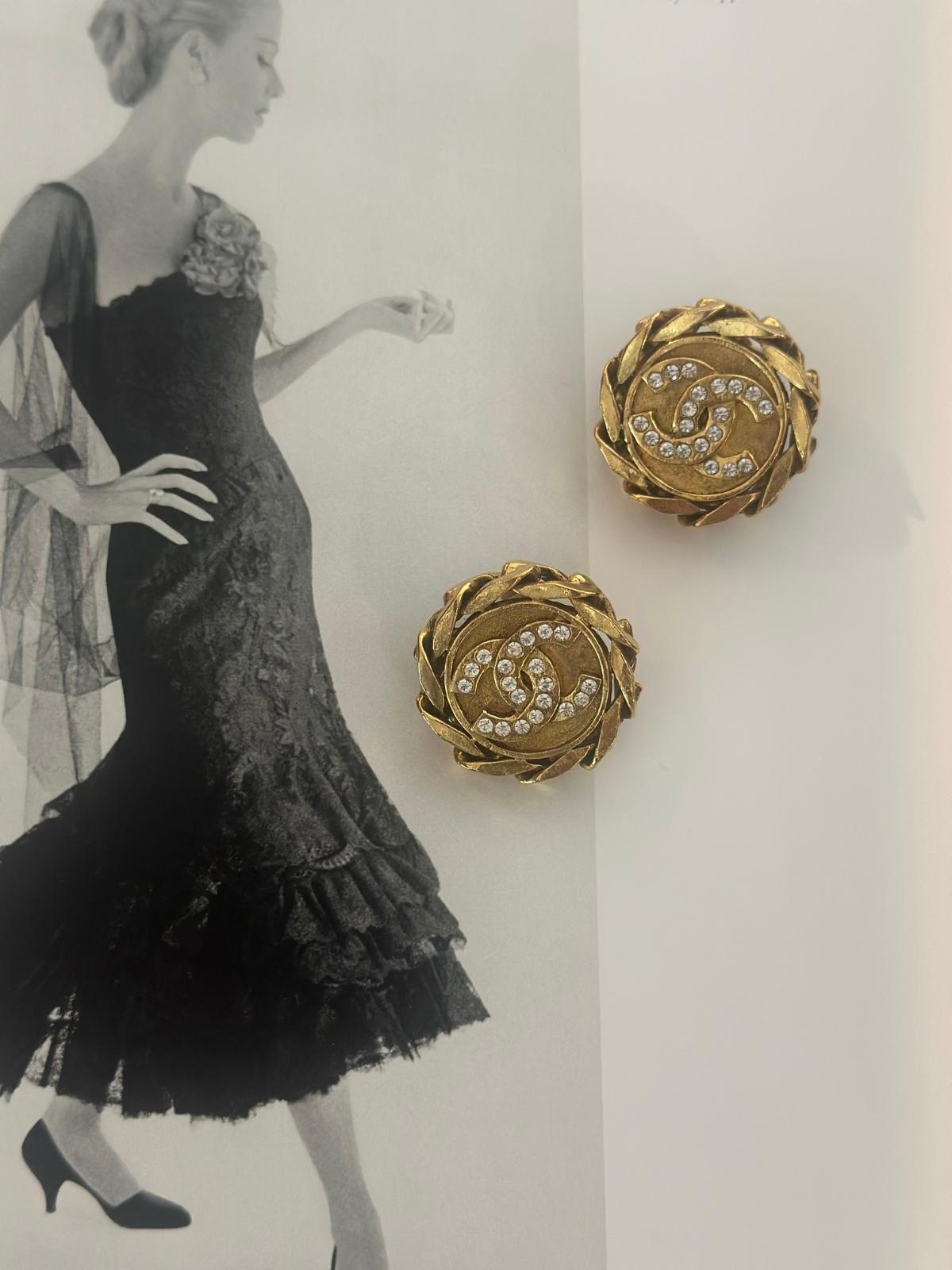 VIntage Chanel Gold earrings with a rhinestone next to an illustration of a woman in a black dress.