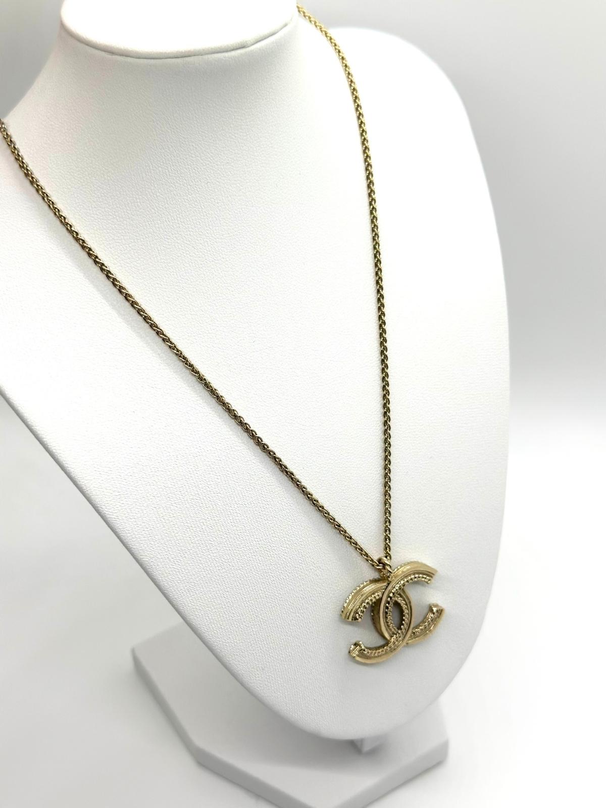 Chanel gold and pearl necklace on white bust form. Back view showing rope detail.