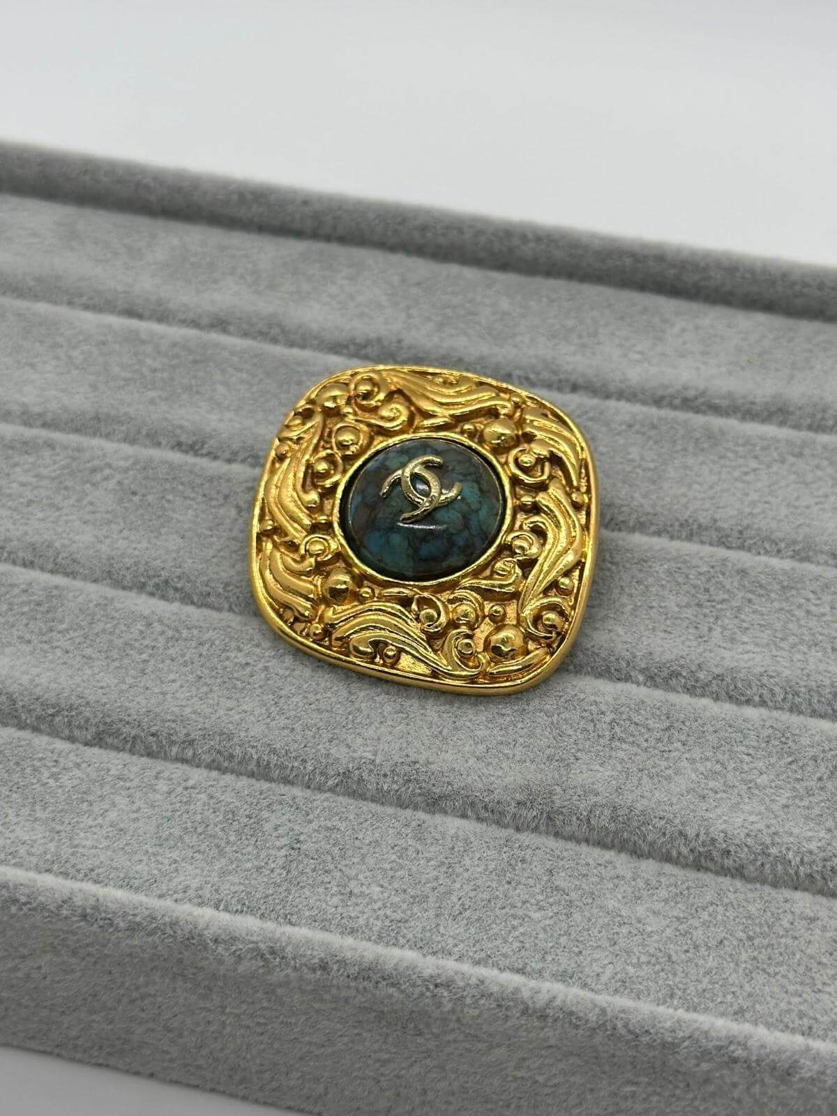 VIntage Chanel Turqoise Brooch on grey background