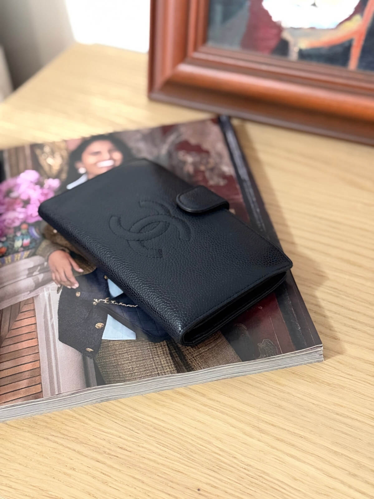 Louise Row featuring vintage Chanel black cavier embossed wallet on table