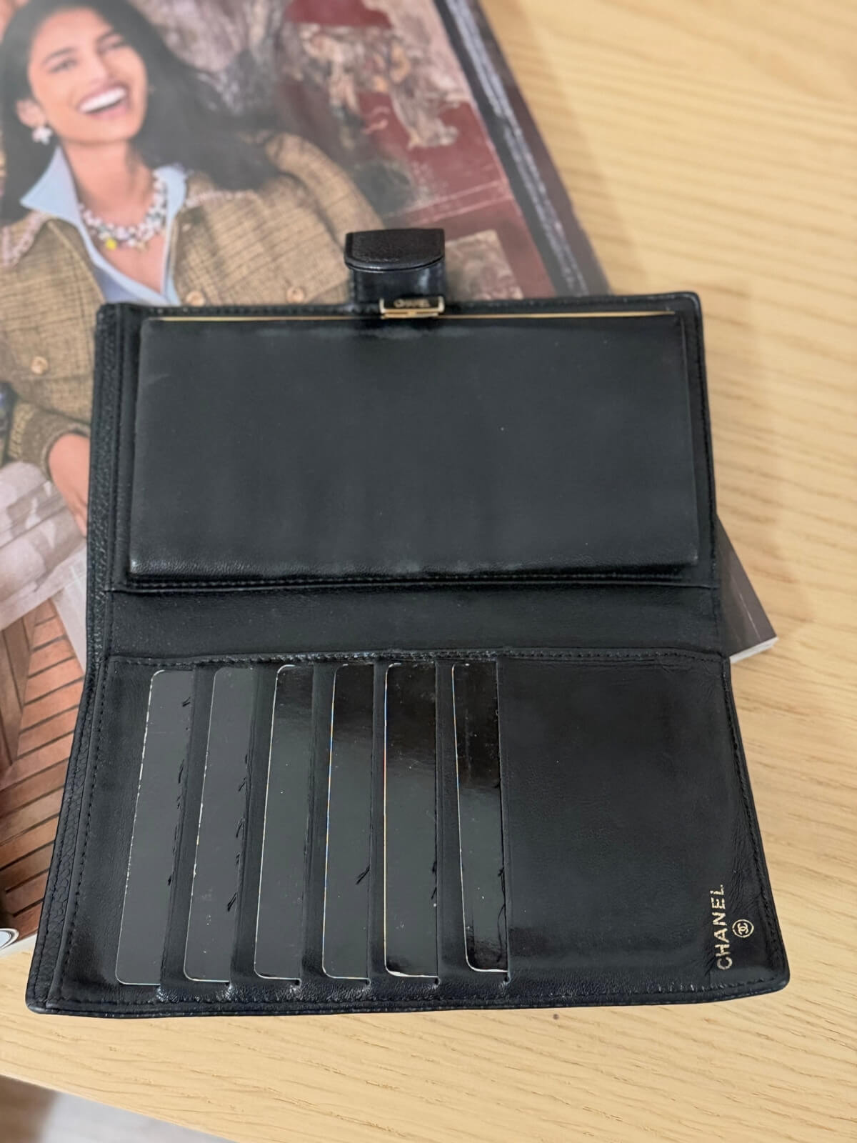 Louise Row featuring vintage Chanel black cavier embossed wallet on table