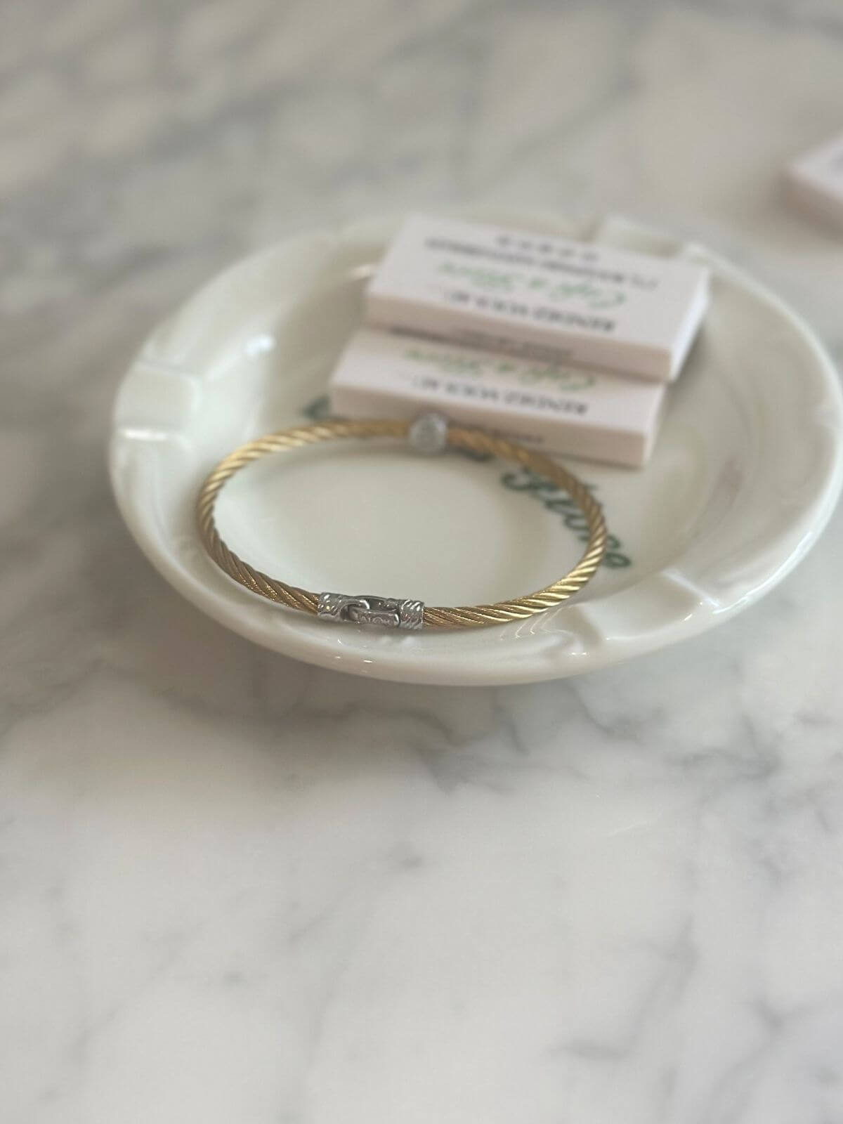 Louise Row Studio featuring Alor cable bracelet on plate on grey table showing clasp