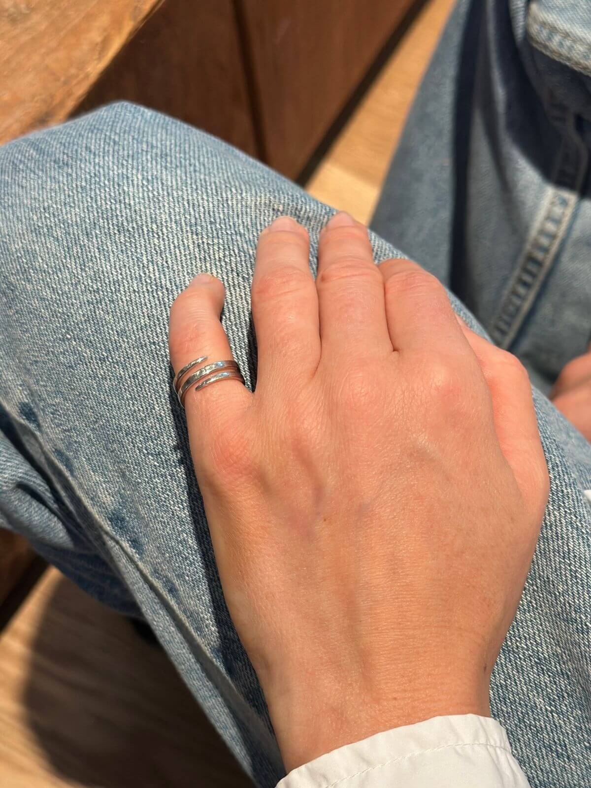 Anita Ko white gold coil ring on model hand on jeans. 