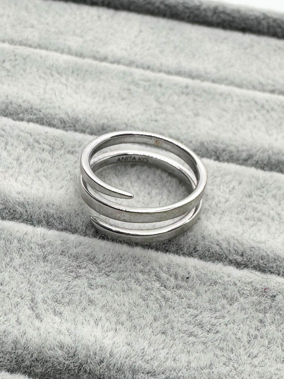 Anita Ko white gold coil ring on grey fixture. Showing signature. 