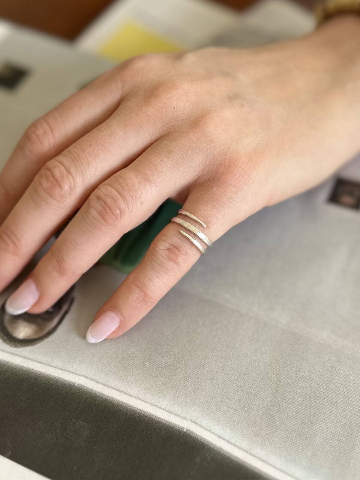 Close-up of a hand with a ring on a metallic surface