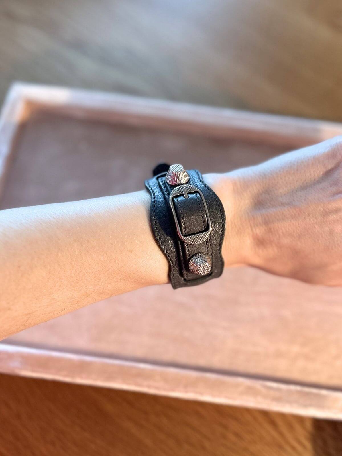Balenciaga leather bracelet on pink display on arm