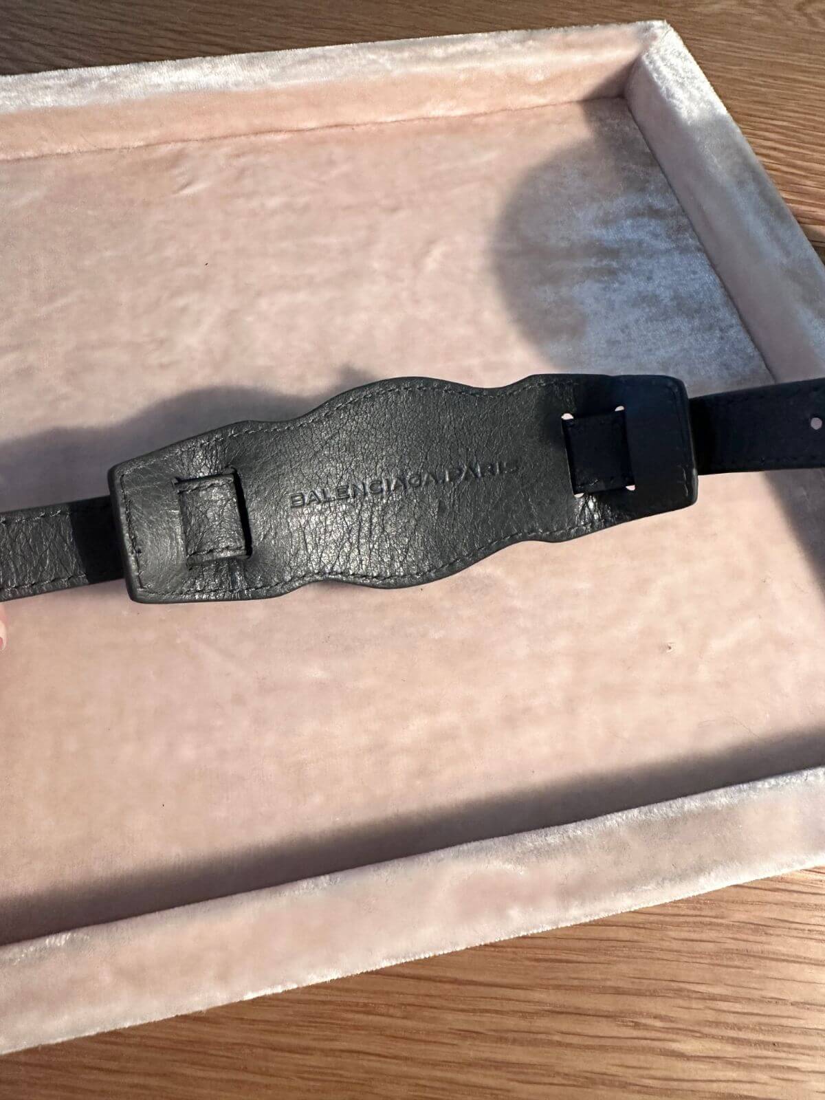 Balenciaga leather bracelet on pink display back side showing stamp