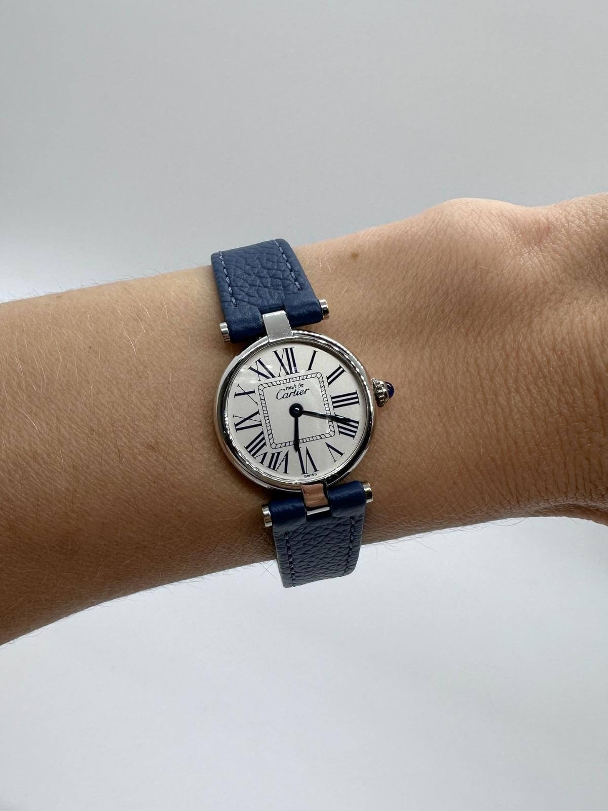 Cartier Vendome Silver watch with blue strap on wrist with white background