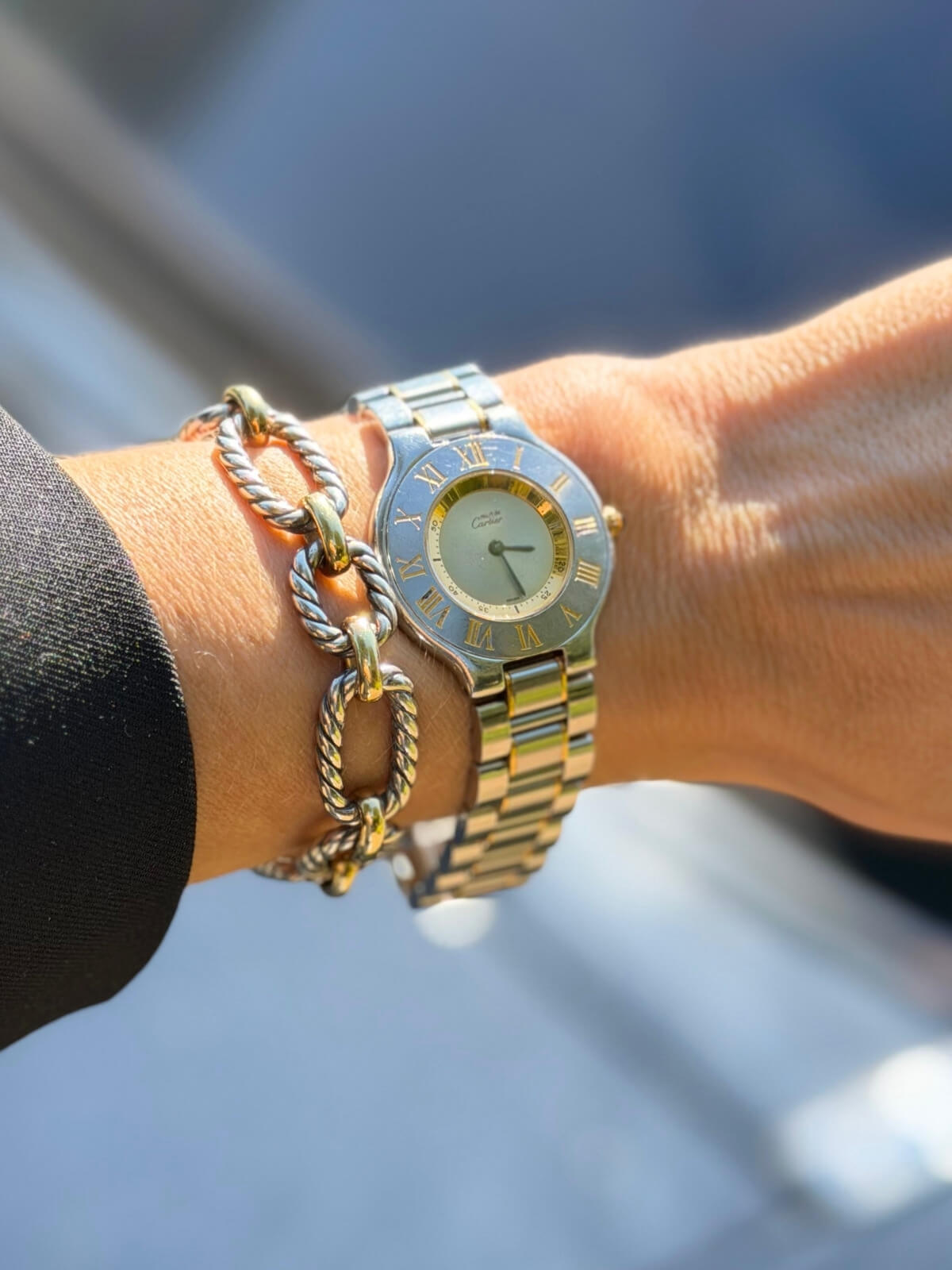 Louise Row featuring Model wearing Cartier must watch in stainless silver and gold round dial.