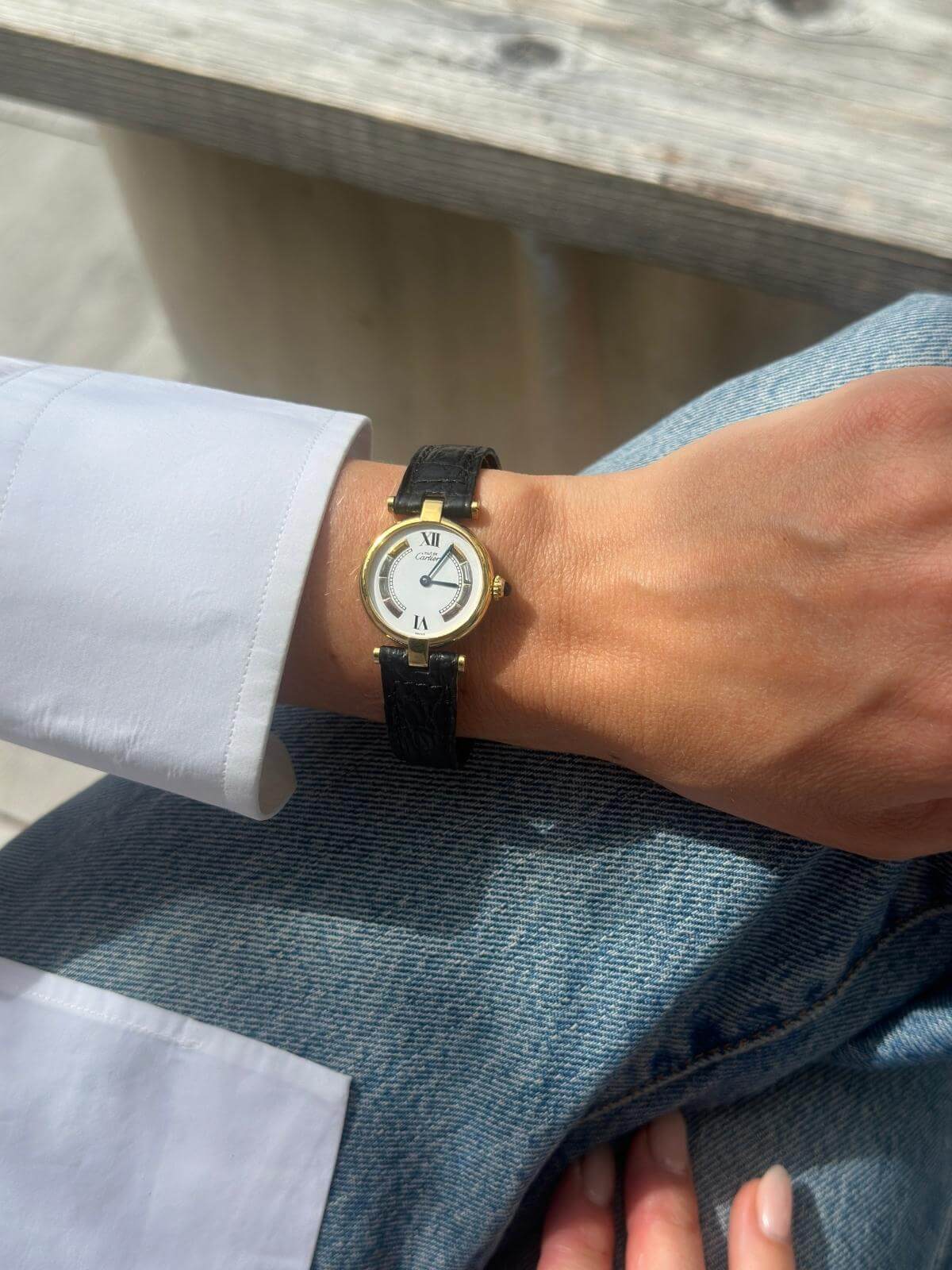 Cartier Gold watch on a wrist with a blurred background