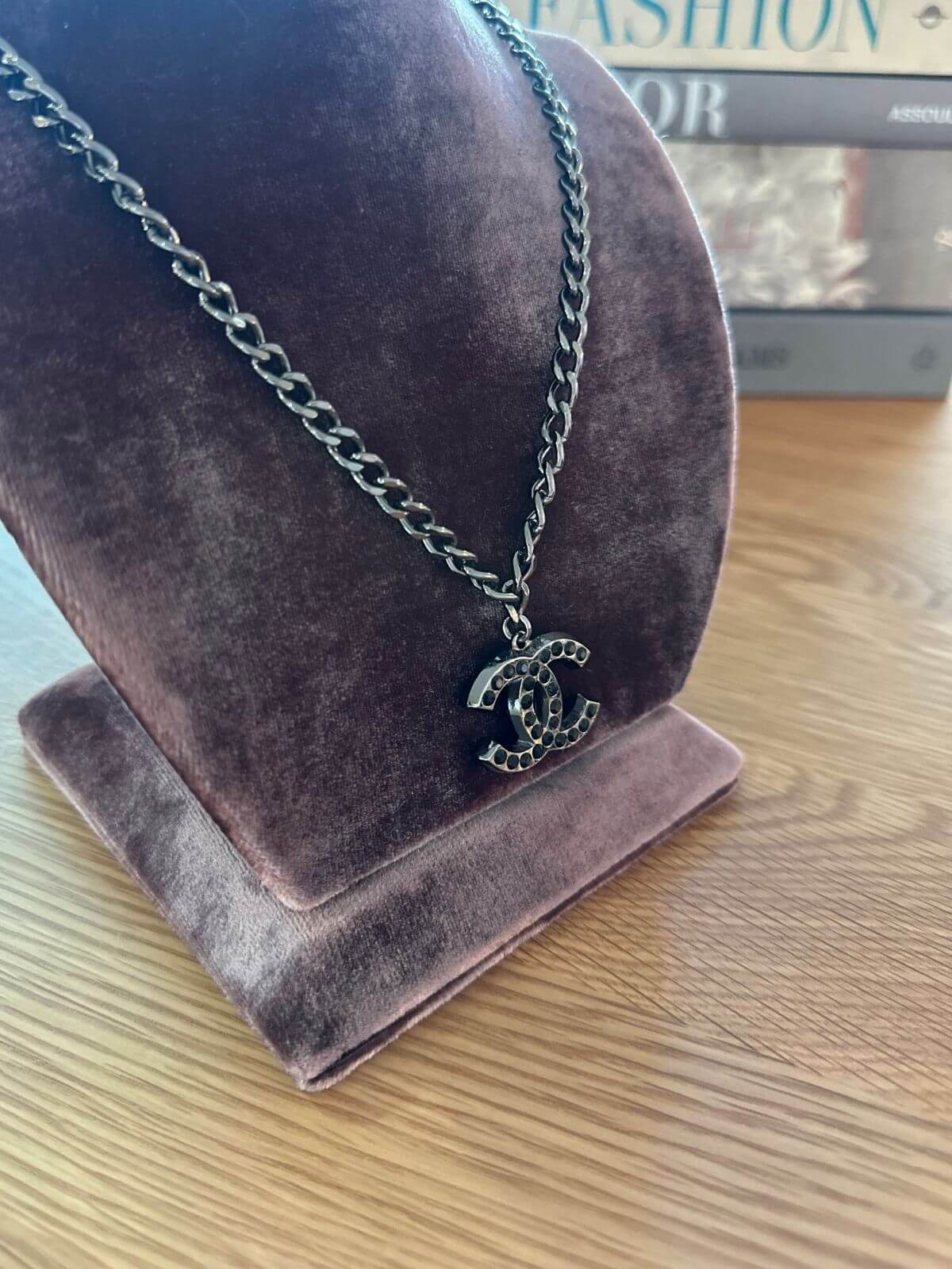 Chanel necklace close up on brown fixture
