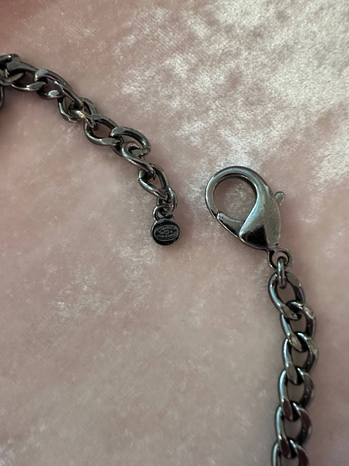 Chanel necklace stamp on pink background