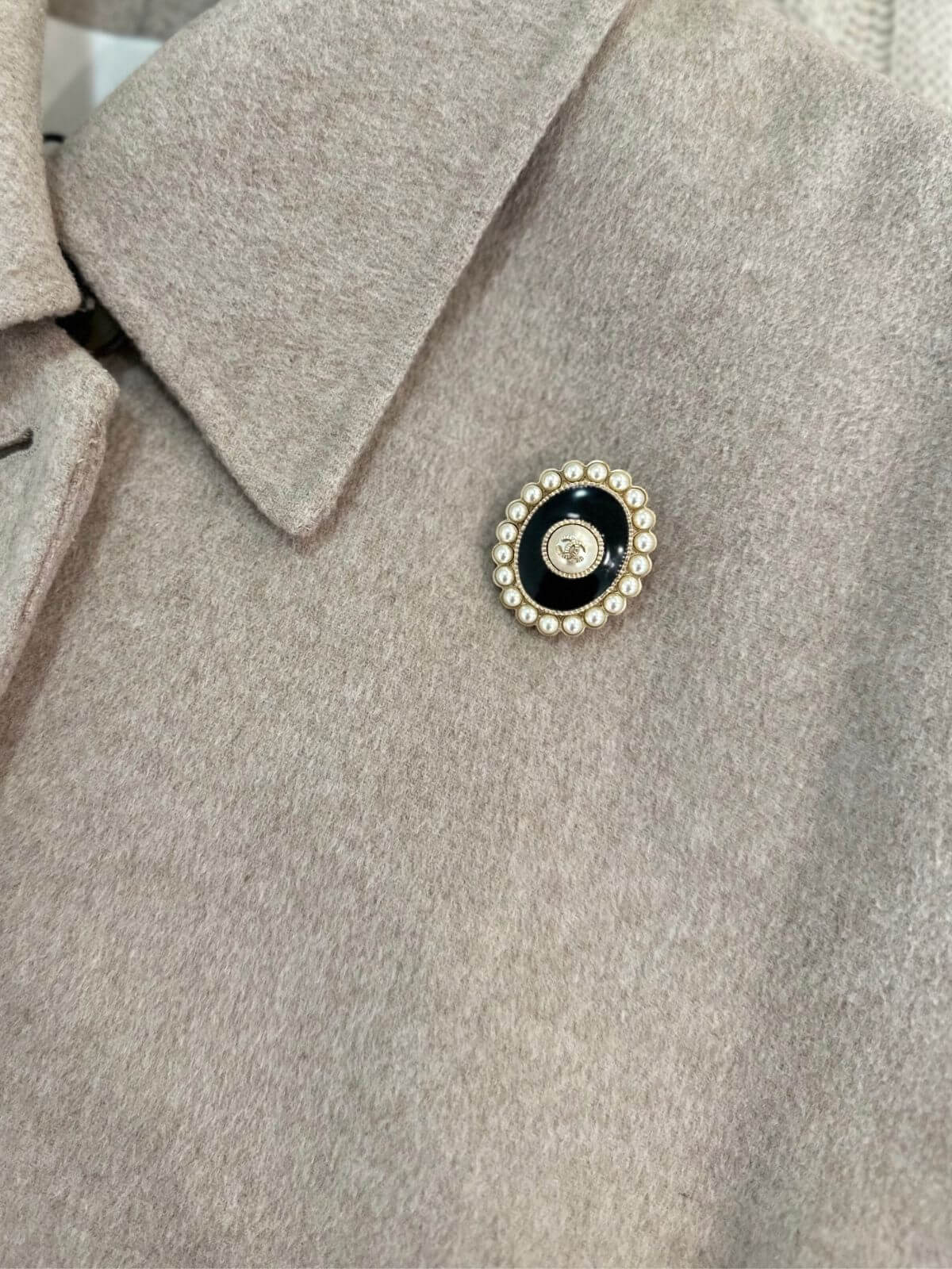 Chanel Oval brooch on beige coat
