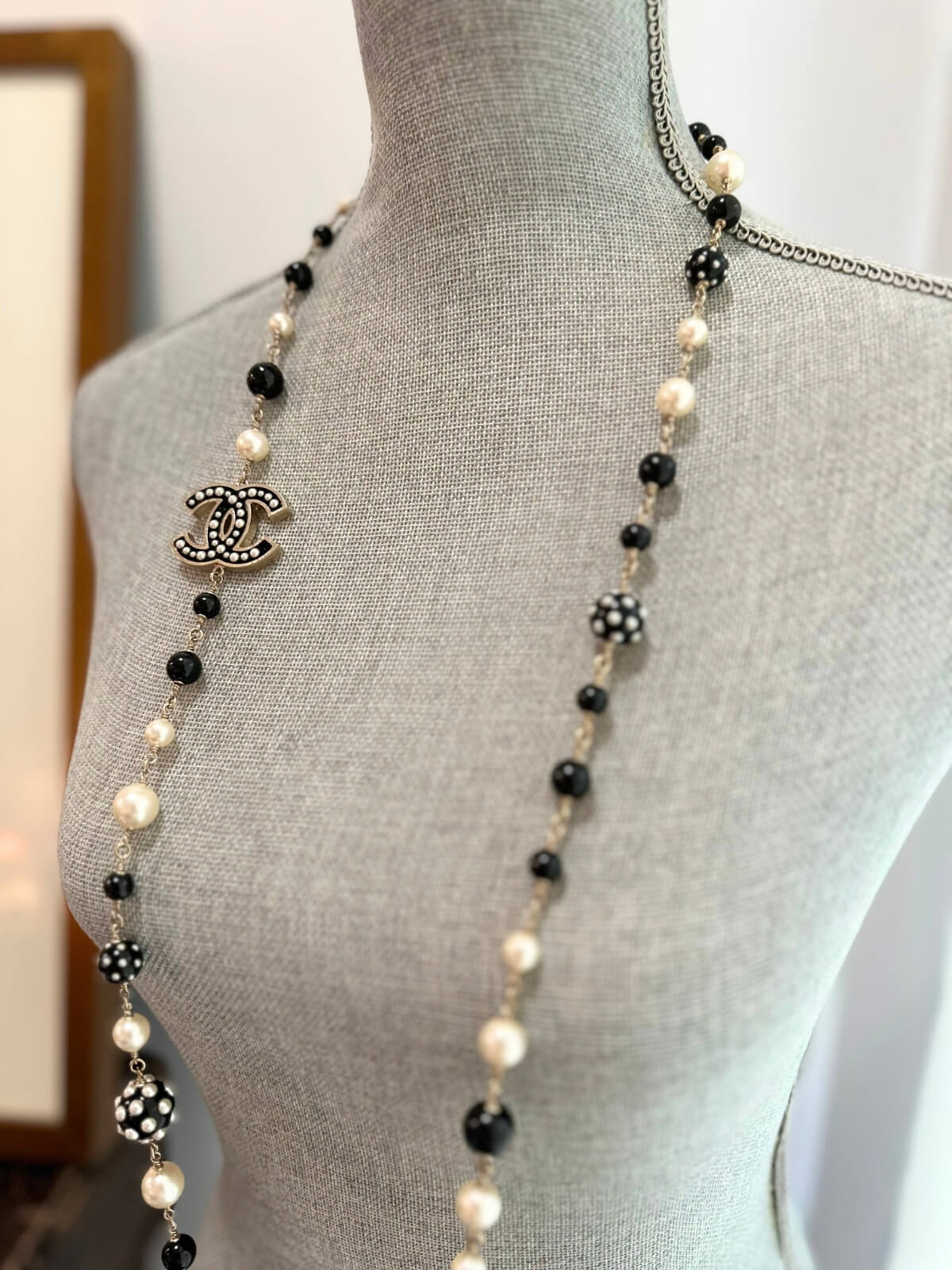 Louise Row featuring Chanel black and white beaded necklace on grey mannequin