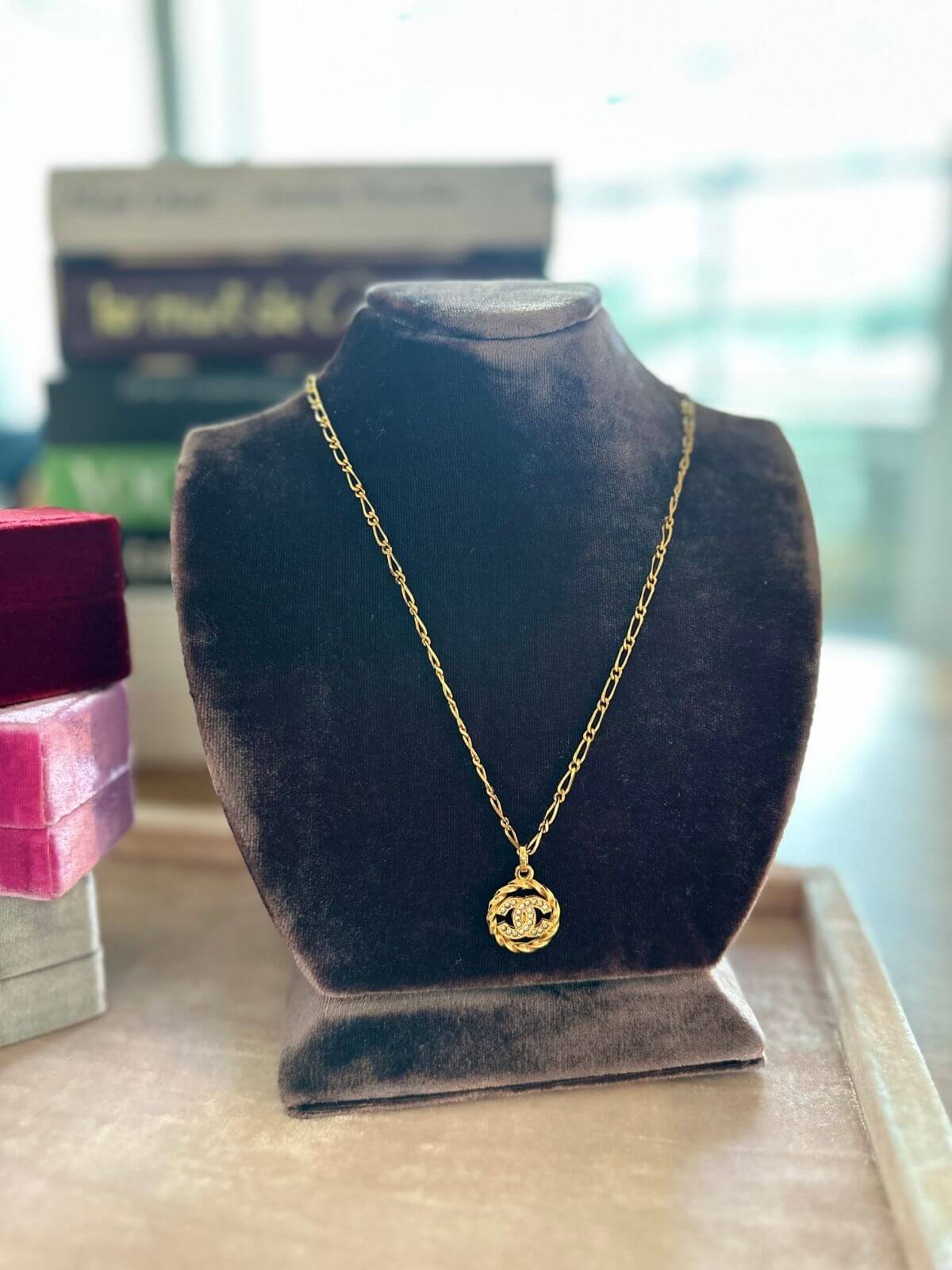 Chanel Gold necklace on a black velvet bust with a blurred background