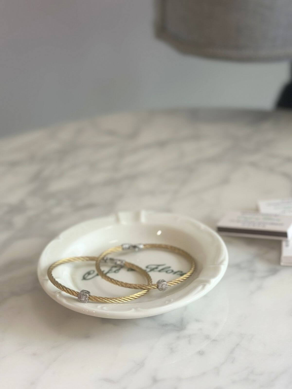 Louise Row Studio featuring Alor and Charriol cable bracelet on plate on grey table