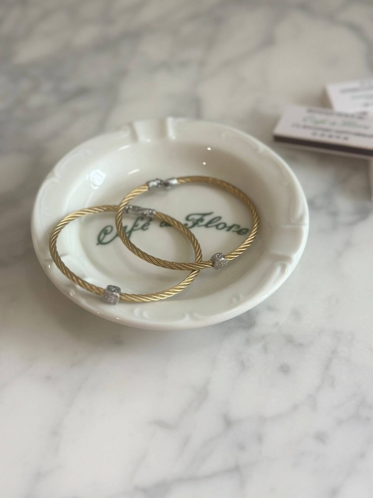 Louise Row Studio featuring Alor and Charriol cable bracelet on plate on grey table