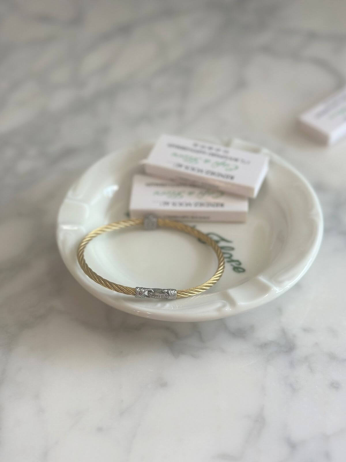 Louise Row Studio featuring Charriol cable bracelet on plate on grey table. 