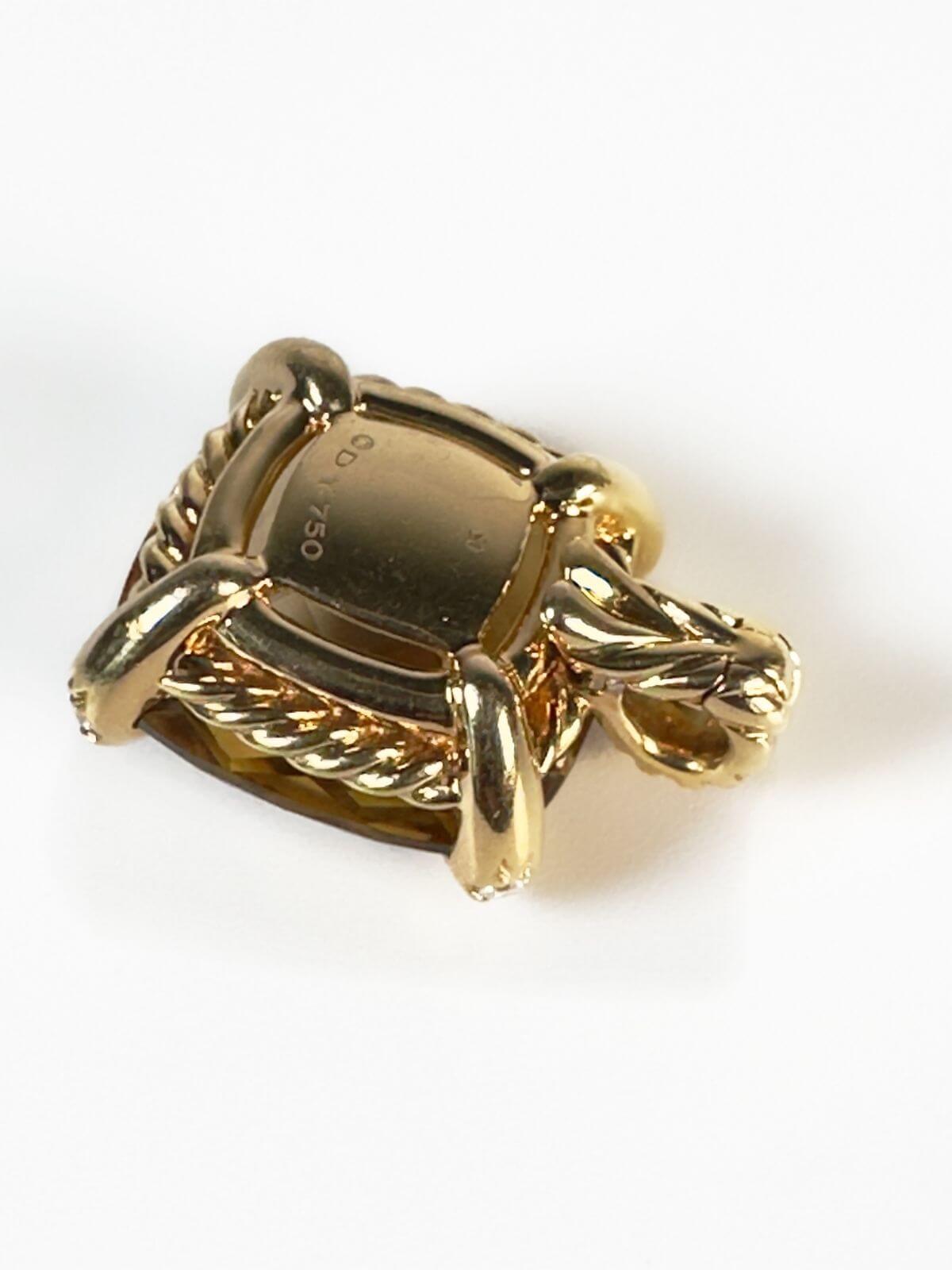 Back of gold pendant with DY signature and cable shown on the back side of the gold piece. 