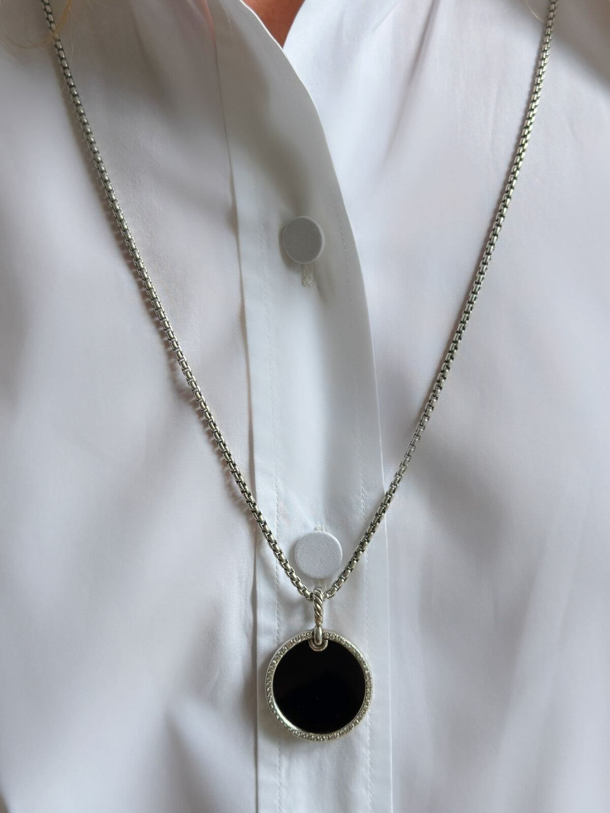 DY black onyx pendant and chain with  on a white shirt