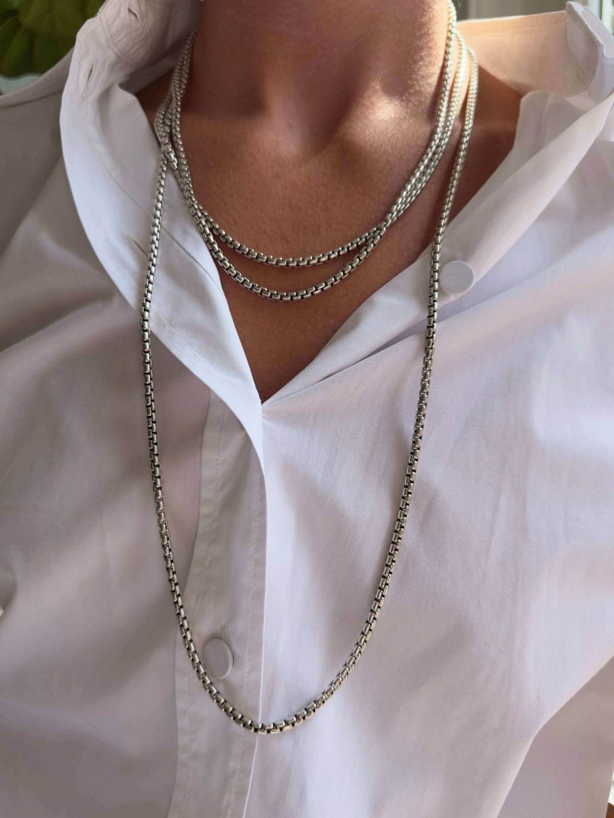 Model in white shirt wearing DY silver chain wrapped long around her neck