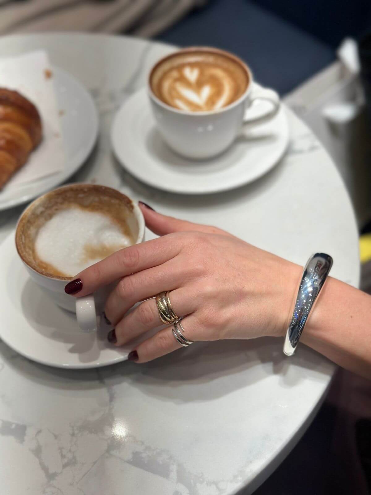 Jewelry on arm, silver David Yurman bracelet at cafe with coffee