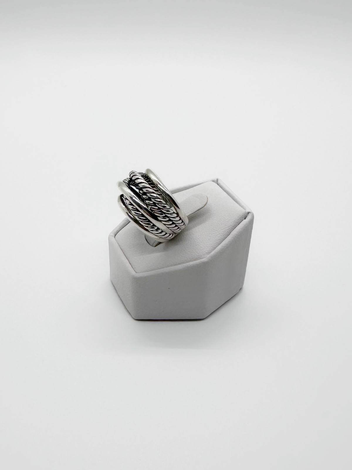 David Yurman Silver ring with textured band on a white stand against a white background
