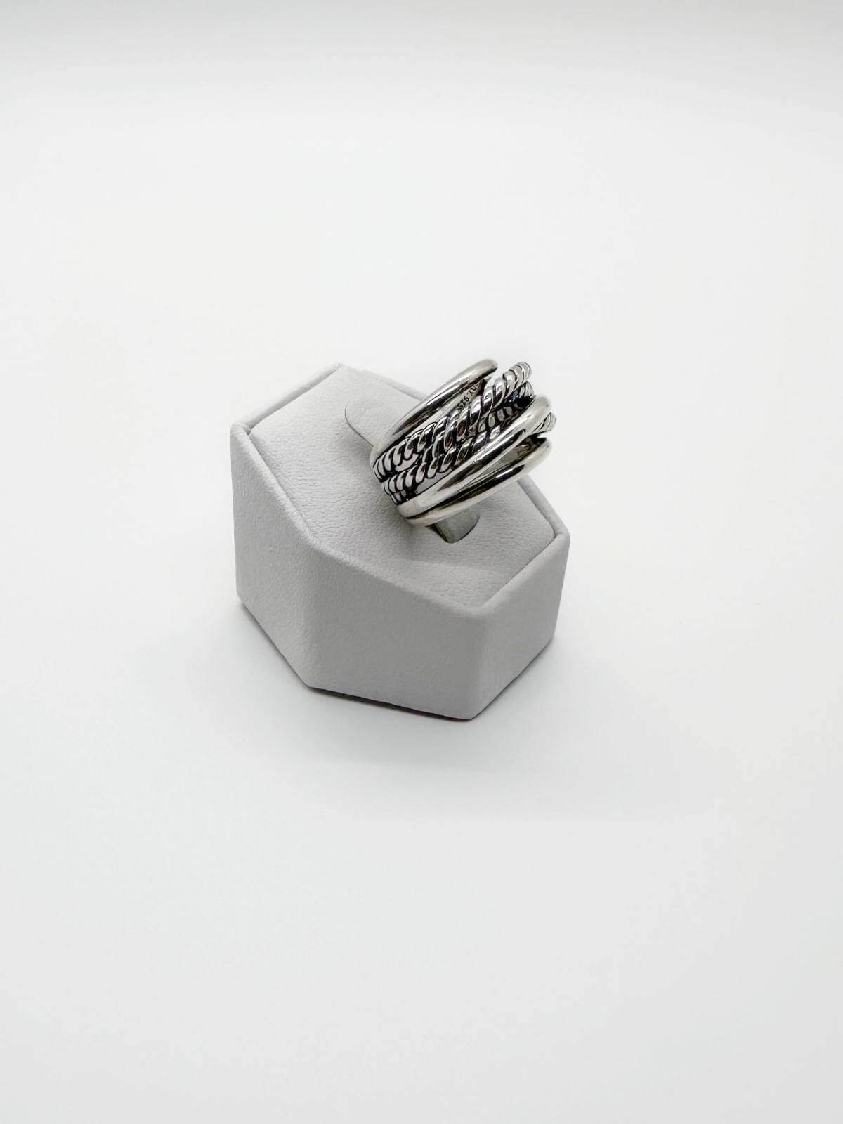 David Yurman Silver ring with textured band on a white stand against a white background