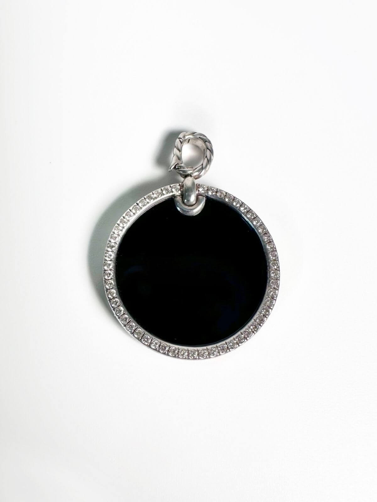 Silver pendant with diamond bezel with center stone black onyx on white background