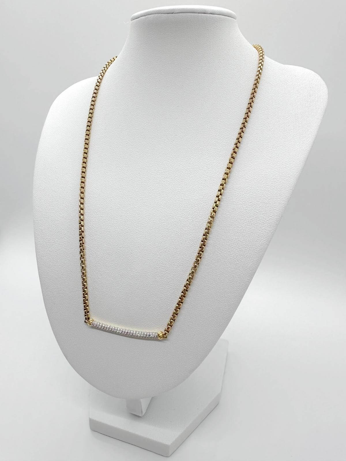 DY diamond bar on Gold chain necklace on a white mannequin bust against a white background