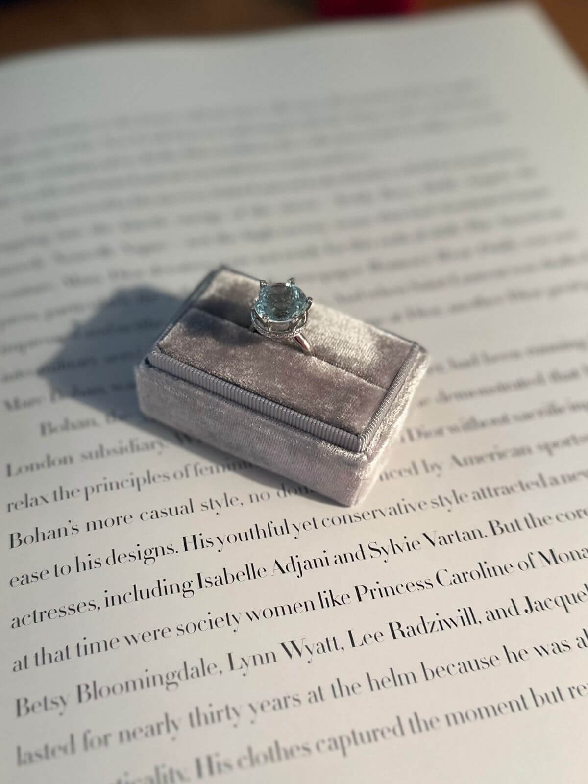 Silver ring in a velvet box on an open book