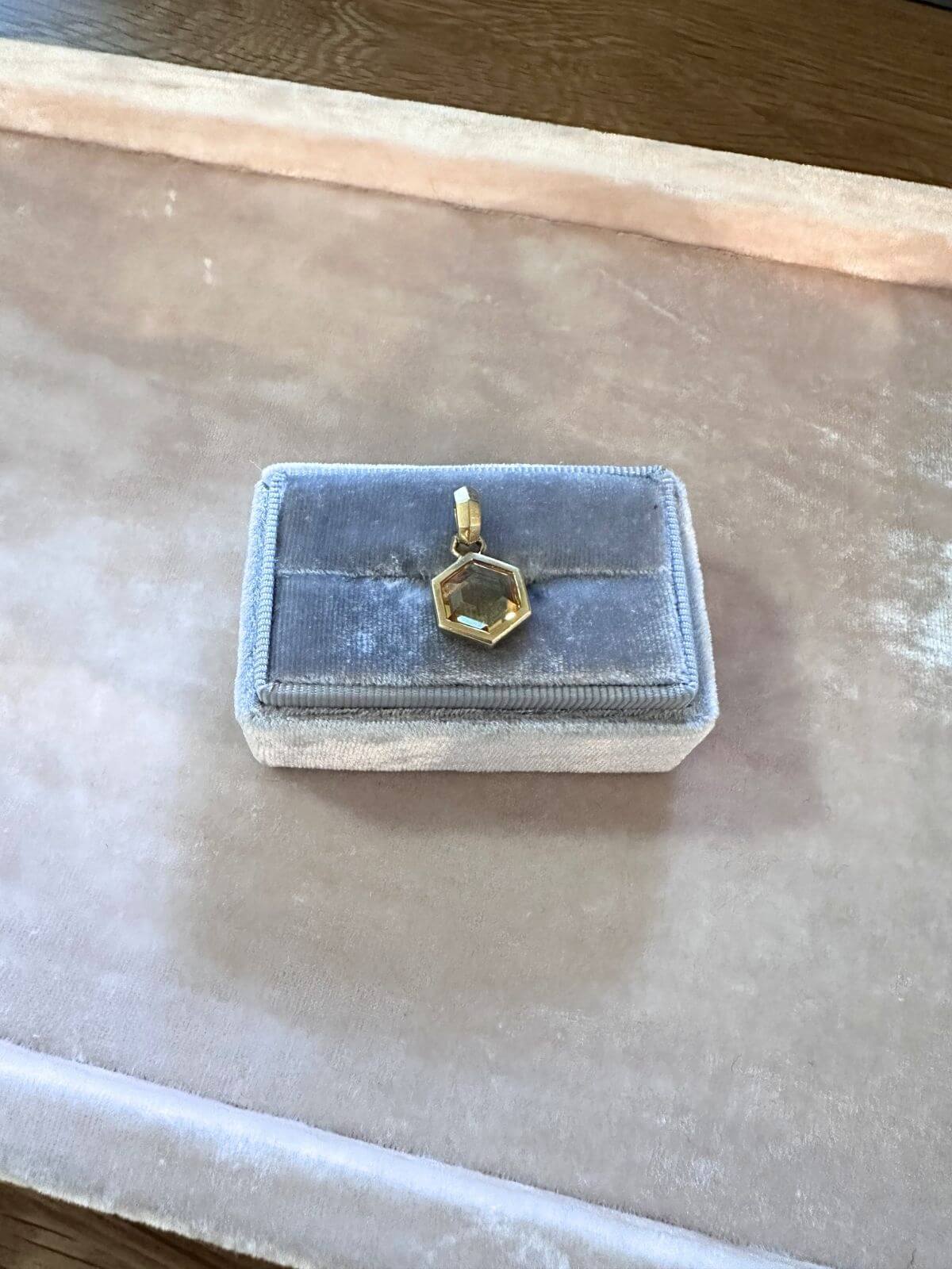 David Yurman Gold necklace with a hexagonal pendant on a pink fixture