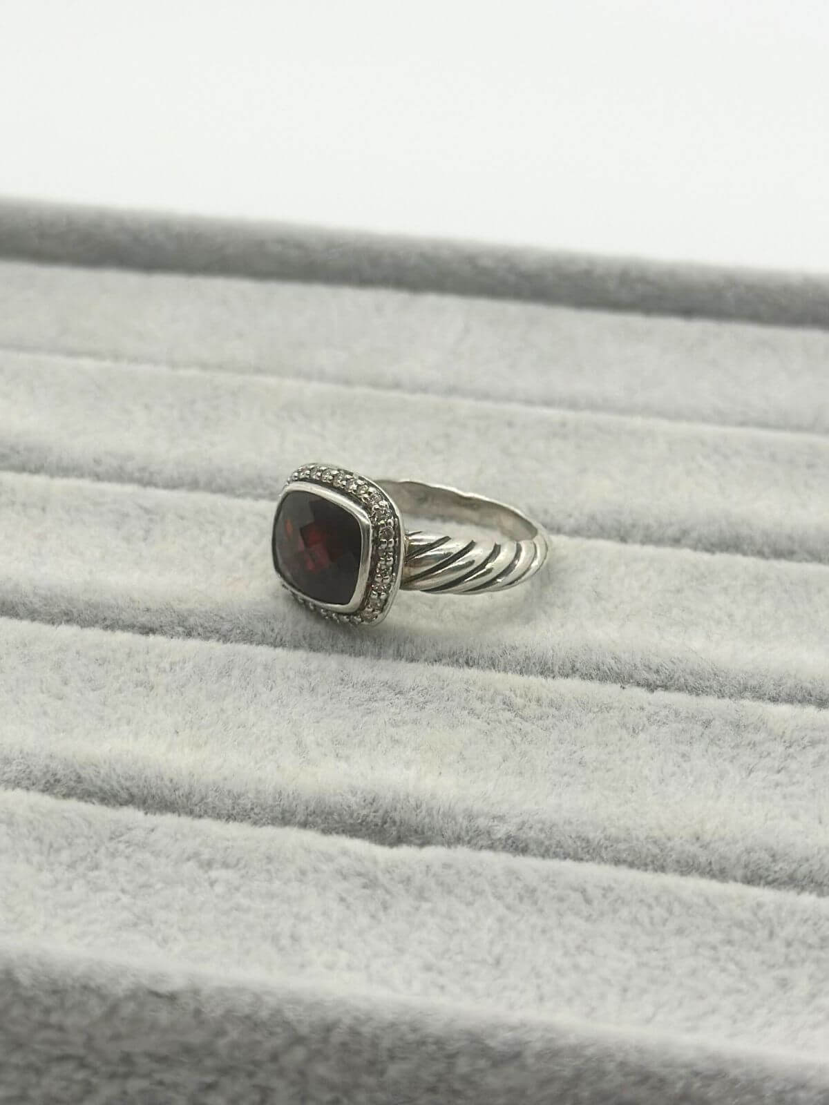 David Yurman Petite Noblesse Ring on grey fixture garnet and dia ring with silver. 