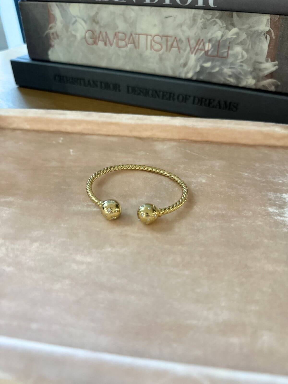 Gold David Yurman Solari bracelet on pink tray