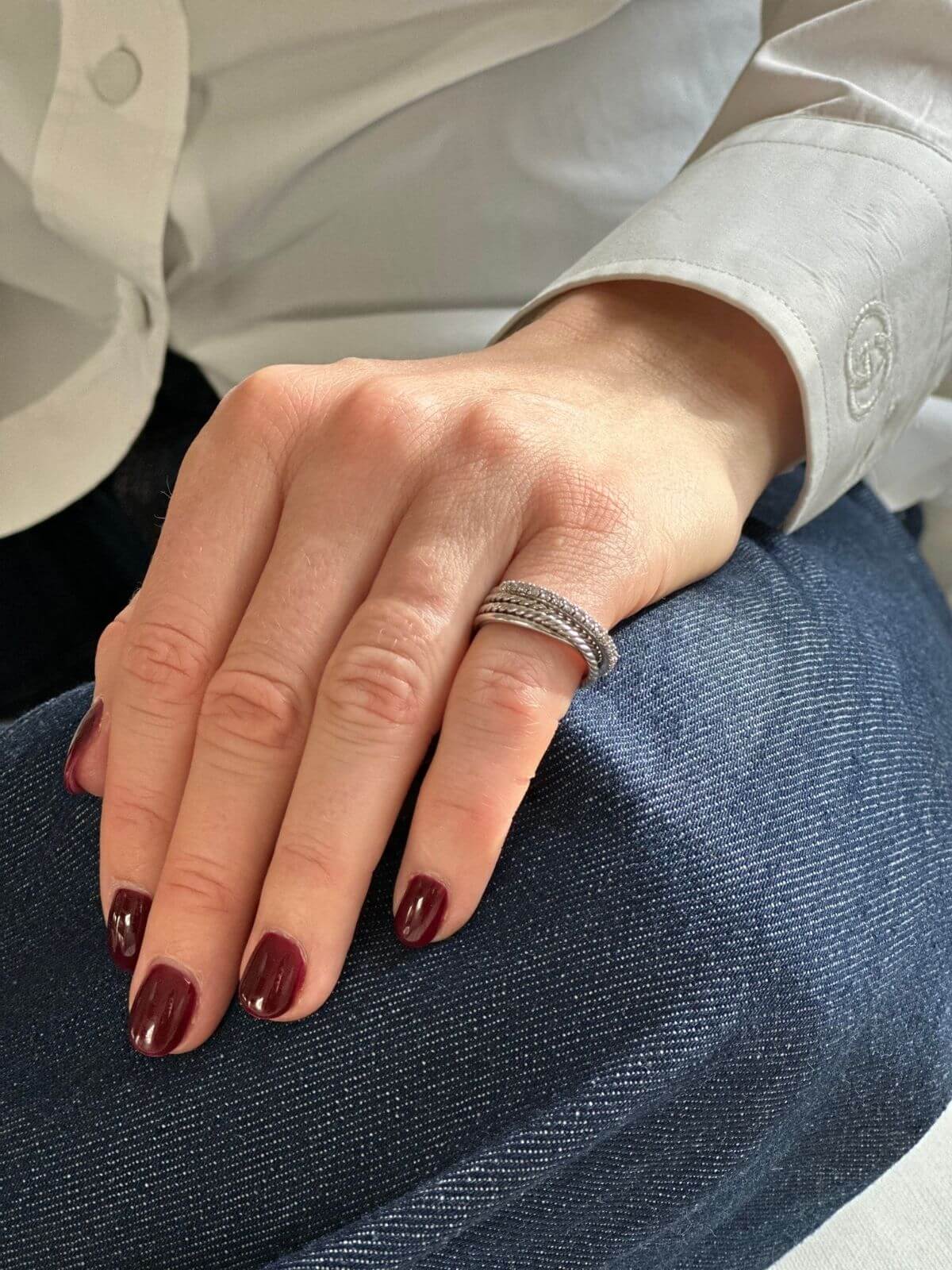 David Yurman silver Crossover ring on pinky finger of model with hand on jeans