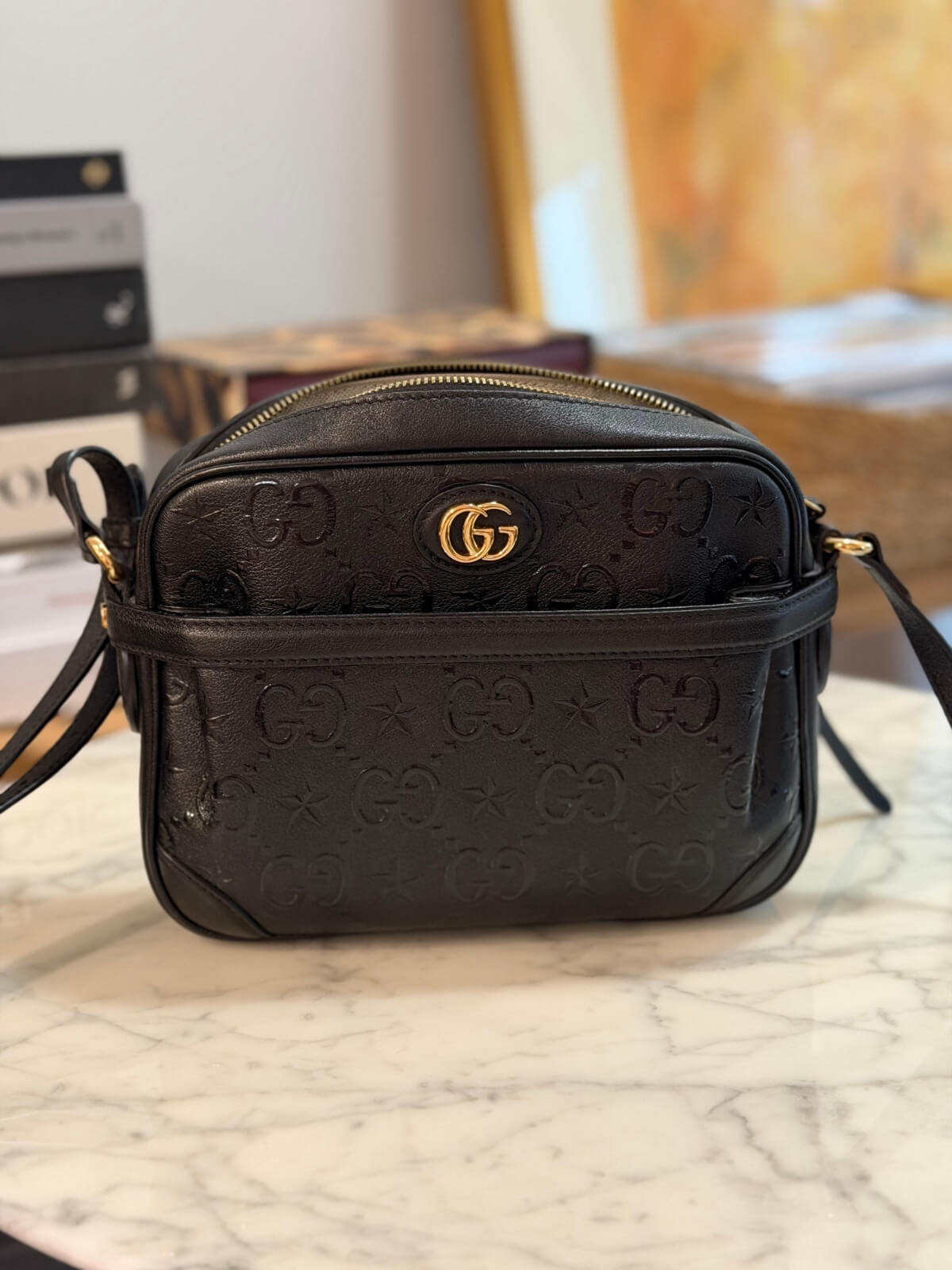 Louise Row featuring Gucci Star Monogram bag on table 