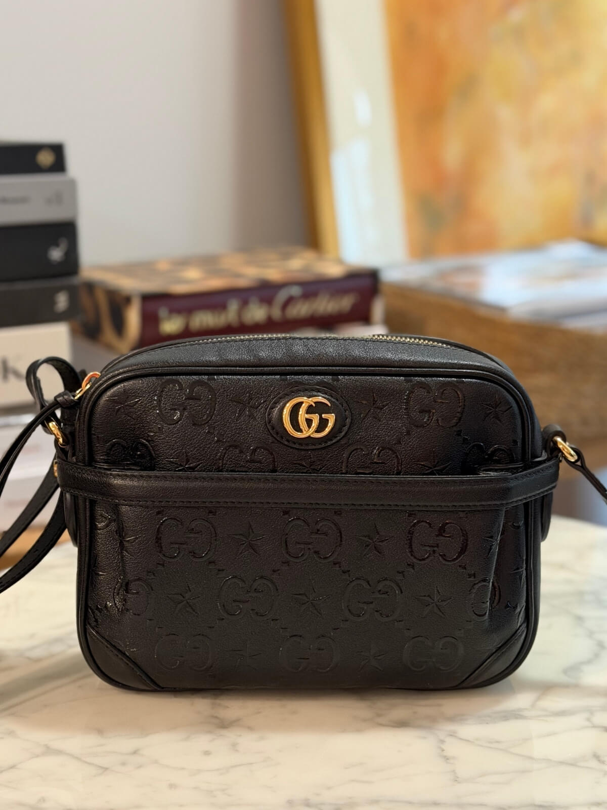 Louise Row featuring Gucci Star Monogram bag on table 