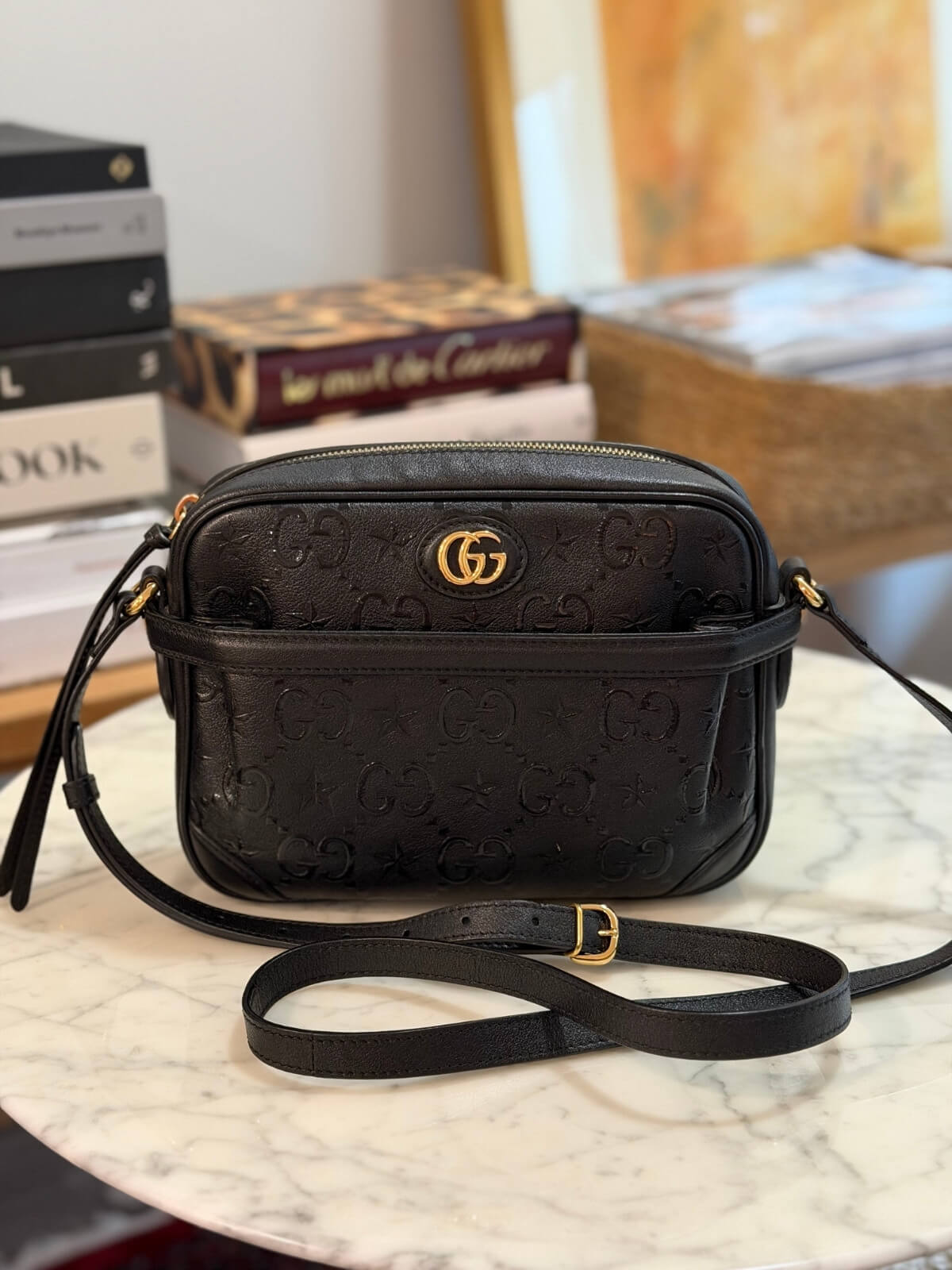 Louise Row featuring Gucci Star Monogram bag on table 